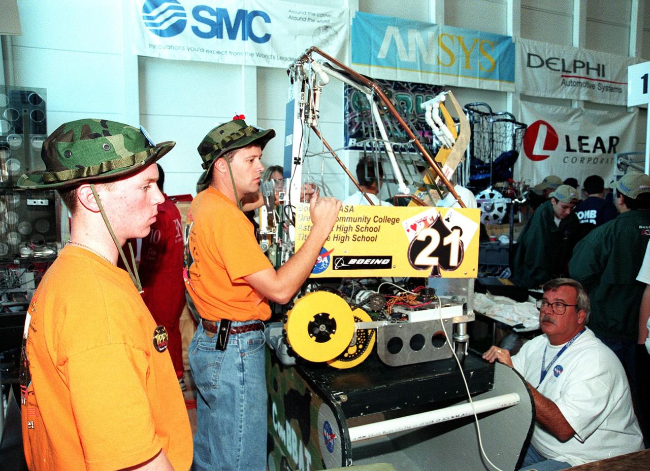 These students from Astronaut High and Titusville High Schools, in Brevard County, Florida, known as the CombBat Team, make adjustments on their robot entered in the 1999 Southeastern Regional robotic competition at Kennedy Space Center Visitor Complex March 4-6. Thirty schools from around the country have converged at KSC for the event that pits gladiator robots against each other in an athletic-style competition. KSC is hosting the event being sponsored by the nonprofit organization For Inspiration and Recognition of Science and Technology, known as FIRST. The FIRST robotics competition is designed to provide students with a hands-on, inside look at engineering and other professional careers