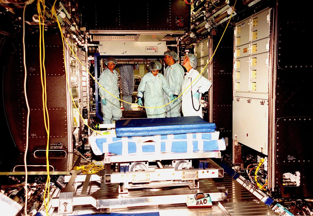 In the Space Station Processing Facility, Marsha Ivins, a mission specialist on the STS-98 crew, inspects the U.S. Laboratory with members of the laboratory's processing team. The laboratory module, considered the centerpiece of the International Space Station (ISS), has been named "Destiny" in honor of its prominent role in the world’s largest science and technology effort. It is planned for launch aboard Space Shuttle Endeavour on the sixth ISS construction flight currently targeted for March 2000. From left to right are Ivins, Danny Whittington (face not visible), Melissa Orozco, Jerry Hopkins, and Suzanne Fase