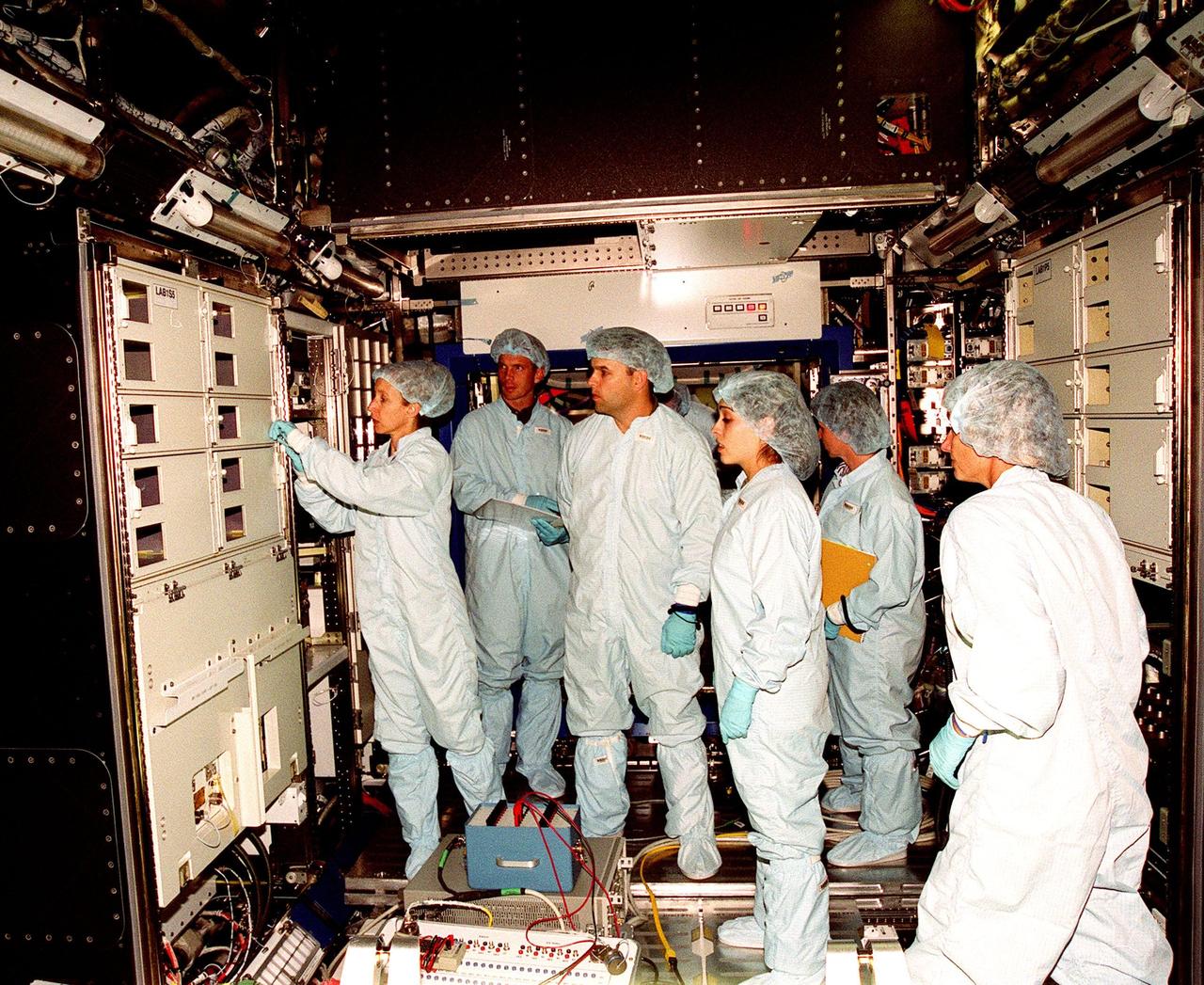 In the Space Station Processing Facility, Marsha Ivins, a mission specialist on the STS-98 crew, inspects the U.S. Laboratory with members of the laboratory's processing team. The laboratory module, considered the centerpiece of the International Space Station (ISS), has been named "Destiny" in honor of its prominent role in the world’s largest science and technology effort. It is planned for launch aboard Space Shuttle Endeavour on the sixth ISS construction flight currently targeted for March 2000. From left to right are Ivins, Jerry Hopkins, Danny Whittington, Melissa Orozco, Vicki Reese and Suzanne Fase