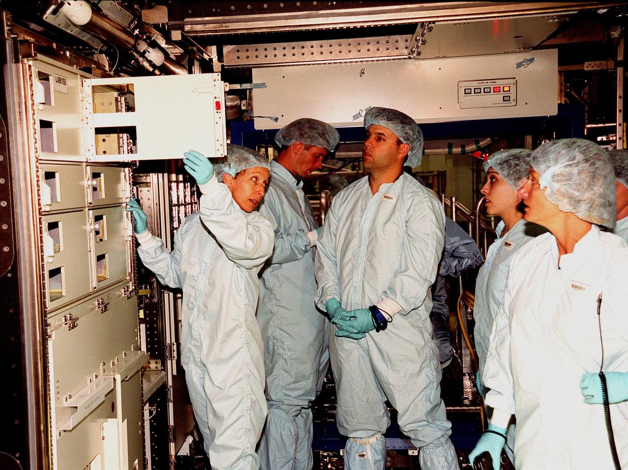 In the Space Station Processing Facility, Marsha Ivins, a mission specialist on the STS-98 crew, inspects the U.S. Laboratory with members of the laboratory's processing team. The laboratory module, considered the centerpiece of the International Space Station (ISS), has been named "Destiny" in honor of its prominent role in the world’s largest science and technology effort. It is planned for launch aboard Space Shuttle Endeavour on the sixth ISS construction flight currently targeted for March 2000. From left to right are Ivins, Jerry Hopkins, Danny Whittington, Melissa Orozco, and Suzanne Fase