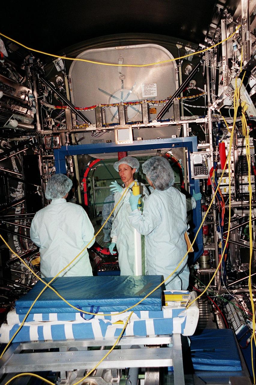 In the Space Station Processing Facility, Marsha Ivins (center), a mission specialist on the STS-98 crew, talks with Suzanne Fase, (left) and Melissa Orozco (right), members of the U.S. Laboratory's processing team. The laboratory module, considered the centerpiece of the International Space Station (ISS), has been named "Destiny" in honor of its prominent role in the world’s largest science and technology effort. It is planned for launch aboard Space Shuttle Endeavour on the sixth ISS construction flight, currently targeted for March 2000.