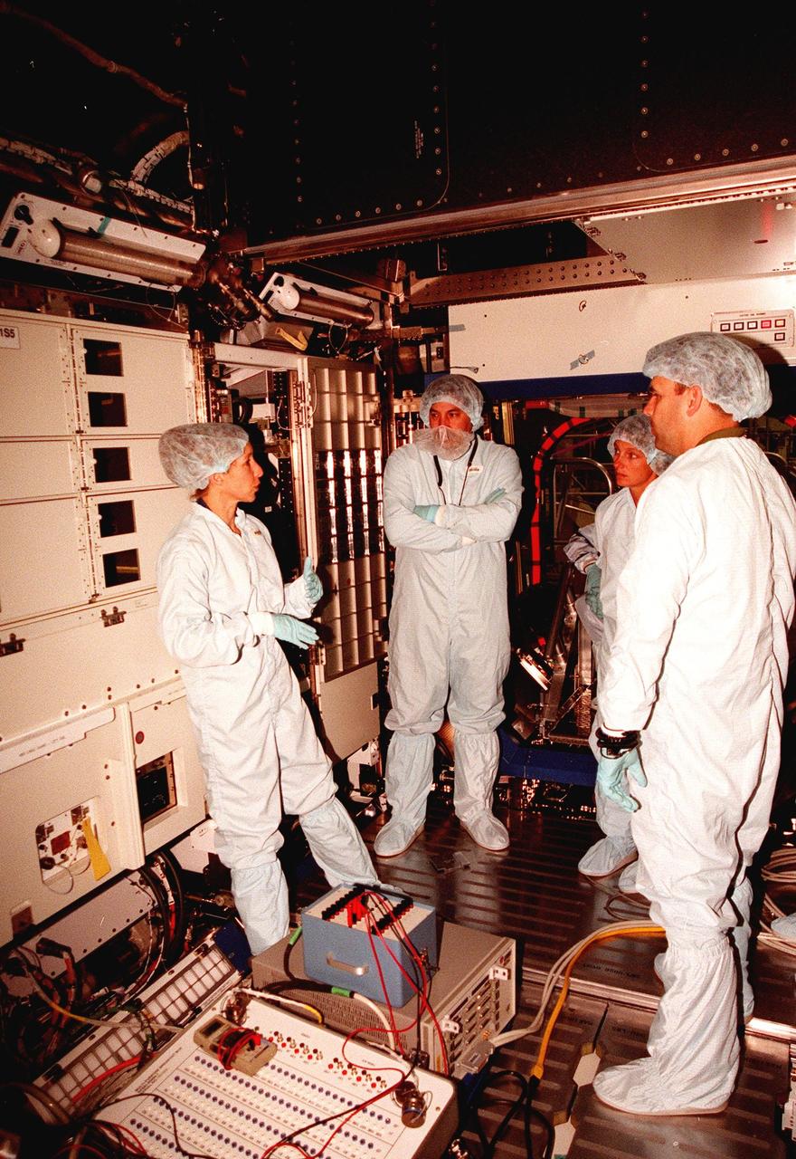 In the Space Station Processing Facility, Marsha Ivins (left), a mission specialist on the STS-98 crew, discusses the U.S. Laboratory with members of the laboratory's processing team, (left to right) James Thews, Suzanne Fase, and Danny Whittington. The laboratory module, considered the centerpiece of the International Space Station (ISS), has been named "Destiny" in honor of its prominent role in the world’s largest science and technology effort. It is planned for launch aboard Space Shuttle Endeavour on the sixth ISS construction flight currently targeted for March 2000