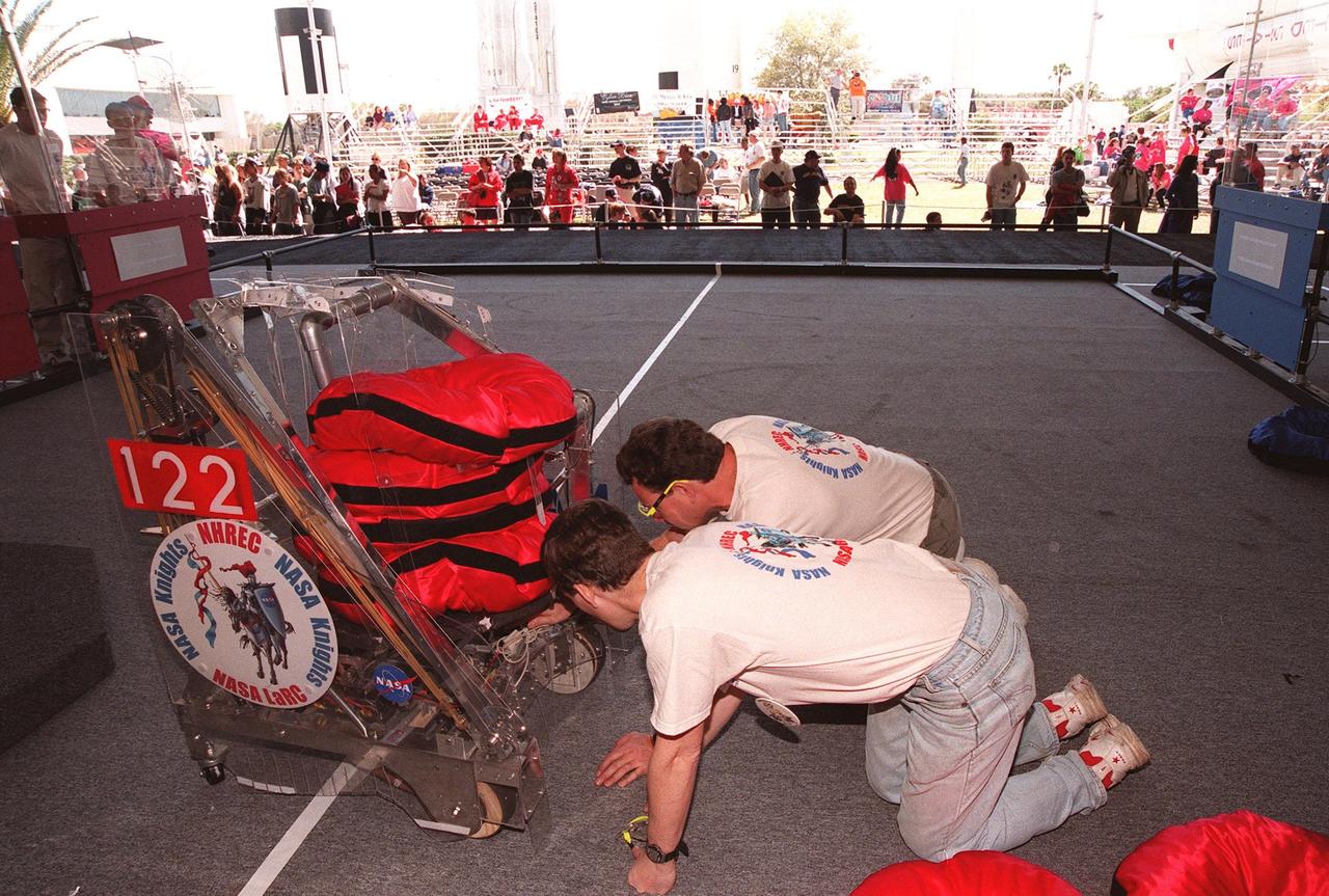 During practice rounds of the 1999 Southeastern Regional robotic competition at Kennedy Space Center Visitor Complex, team members adjust components of their robot on the floor. Thirty schools from around the country have converged at KSC for the event that pits gladiator robots against each other in an athletic-style competition. The robots have to retrieve pillow-like disks from the floor, as well as climb onto a platform and raise the cache of pillows to a height of eight feet. KSC is hosting the event being sponsored by the nonprofit organization For Inspiration and Recognition of Science and Technology, known as FIRST. The FIRST robotics competition is designed to provide students with a hands-on, inside look at engineering and other professional careers