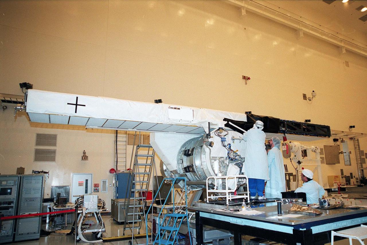 In the Multi-Payload Processing Facility, Mary Reaves and Richard Rainen, with the Jet Propulsion Laboratory, work on the carrier and horizontal antenna mast for the STS-99 Shuttle Radar Topography Mission (SRTM) while Larry Broms watches. The SRTM consists of a specially modified radar system that will fly onboard the Space Shuttle during an 11-day mission in September 1999. This radar system will gather data that will result in the most accurate and complete topographic map of the Earth's surface that has ever been assembled. SRTM is an international project spearheaded by the National Imagery and Mapping Agency and NASA, with participation of the German Aerospace Center DLR. Its objective is to obtain the most complete high-resolution digital topographic database of the Earth