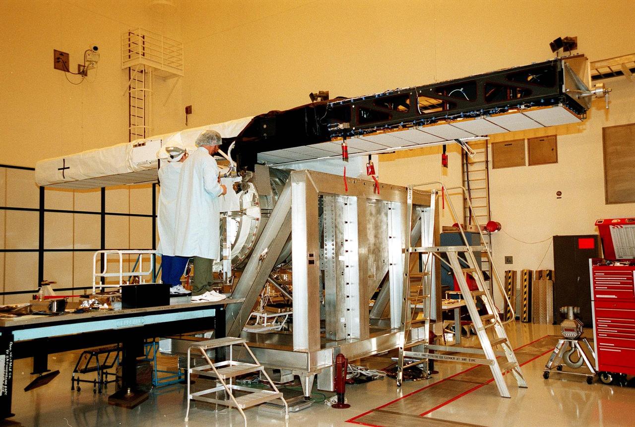In the Multi-Payload Processing Facility, Mary Reaves (left) and Richard Rainen, with the Jet Propulsion Laboratory, check out the carrier and horizontal antenna mast for the STS-99 Shuttle Radar Topography Mission (SRTM). The SRTM consists of a specially modified radar system that will fly onboard the Space Shuttle during an 11-day mission in September 1999. This radar system will gather data that will result in the most accurate and complete topographic map of the Earth's surface that has ever been assembled. SRTM is an international project spearheaded by the National Imagery and Mapping Agency and NASA, with participation of the German Aerospace Center DLR. Its objective is to obtain the most complete high-resolution digital topographic database of the Earth