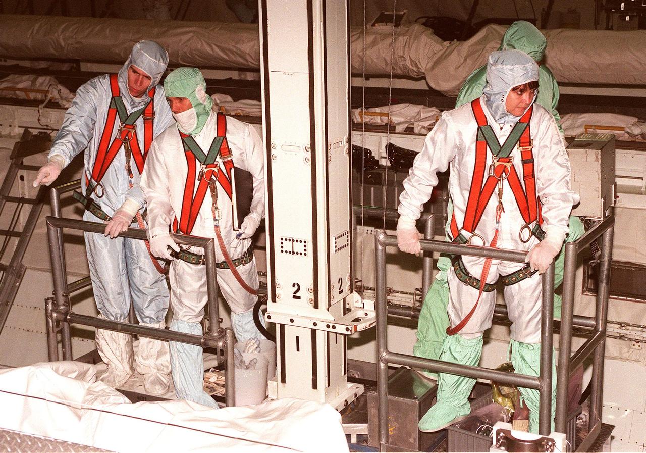 In the Orbiter Processing Facility bay 1, STS-96 Mission Specialists Daniel Barry (M.D., Ph.D.), Valery Ivanovich Tokarev and Tamara E. Jernigan (Ph.D.) look into the payload bay of the orbiter Discovery. The STS-96 crew is at KSC for a Crew Equipment Interface Test. Other crew members participating are Commander Kent V. Rominger, Pilot Rick Douglas Husband, and Mission Specialists Ellen Ochoa (Ph.D.) and Julie Payette, with the Canadian Space Agency. The primary payload of STS-96 is the SPACEHAB Double Module. In addition, the Space Shuttle will carry unpressurized cargo such as the external Russian cargo crane known as STRELA; the Spacehab Oceaneering Space System Box (SHOSS), which is a logistics items carrier; and an ORU Transfer Device (OTD), a U.S.-built crane that will be stowed on the station for use during future ISS assembly missions. These cargo items will be stowed on the International Cargo Carrier, fitted inside the payload bay behind the SPACEHAB module. STS-96 is targeted for launch on May 24 from Launch Pad 39B