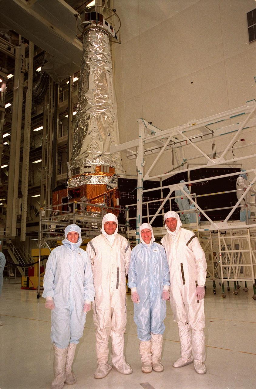 During payload familiarization, four members of the STS-93 crew pose in front of the Chandra X-ray Observatory, which is in the Vertical Processing Facility. From left are Commander Eileen Collins, Mission Specialists Michel Tognini of France and Catherine G. Coleman, and Pilot Jeffrey S. Ashby. Tognini represents the Centre National d'Etudes Spatiales (CNES). Collins is the first woman to serve as a shuttle mission commander. She was the first woman pilot of a Space Shuttle, on mission STS-63, and also served as pilot on mission STS-84. The fifth member of the STS-93 crew is Mission Specialist Steven A. Hawley. Chandra is scheduled for launch July 9 aboard Space Shuttle Columbia, on mission STS-93 . Formerly called the Advanced X-ray Astrophysics Facility, Chandra comprises three major elements: the spacecraft, the science instrument module (SIM), and the world's most powerful X-ray telescope. Chandra will allow scientists from around the world to see previously invisible black holes and high-temperature gas clouds, giving the observatory the potential to rewrite the books on the structure and evolution of our universe