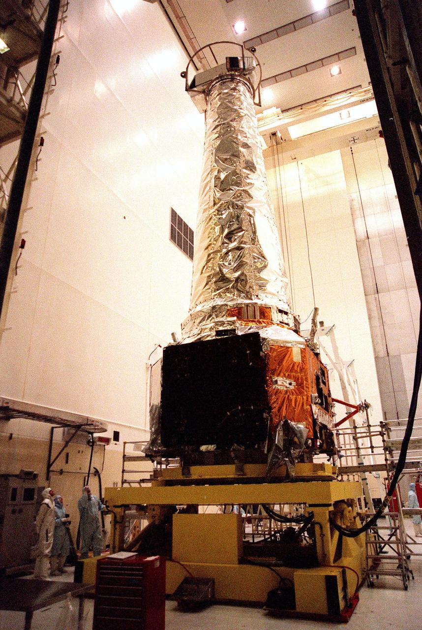 In the Vertical Processing Facility, STS-93 Pilot Jeffrey S. Ashby and Commander Eileen Collins join a TRW technician observing the Chandra X-ray Observatory on top of a work stand. Other members of the STS-93 crew who are at KSC for payload familiarization are Mission Specialists Catherine G. Coleman and Michel Tognini of France, who represents the Centre National d'Etudes Spatiales (CNES). Collins is the first woman to serve as a shuttle mission commander. She was the first woman pilot of a Space Shuttle, on mission STS-63, and also served as pilot on mission STS-84. The fifth member of the crew is Mission Specialist Steven A. Hawley. Chandra is scheduled for launch July 9 aboard Space Shuttle Columbia, on mission STS-93 . Formerly called the Advanced X-ray Astrophysics Facility, Chandra comprises three major elements: the spacecraft, the science instrument module (SIM), and the world's most powerful X-ray telescope. Chandra will allow scientists from around the world to see previously invisible black holes and high-temperature gas clouds, giving the observatory the potential to rewrite the books on the structure and evolution of our universe
