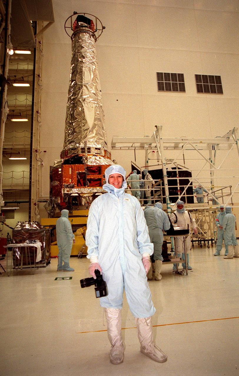 STS-93 Commander Eileen Collins poses with her camera in front of the Chandra X-ray Observatory during payload familiarization. Other members of the STS-93 crew who are at KSC are Pilot Jeffrey S. Ashby and Mission Specialists Catherine G. Coleman and Michel Tognini of France, who represents the Centre National d'Etudes Spatiales (CNES). Collins is the first woman to serve as a shuttle mission commander. She was the first woman pilot of a Space Shuttle, on mission STS-63, and also served as pilot on mission STS-84. The fifth member of the crew is Mission Specialist Steven A. Hawley. Chandra is scheduled for launch July 9 aboard Space Shuttle Columbia, on mission STS-93 . Formerly called the Advanced X-ray Astrophysics Facility, Chandra comprises three major elements: the spacecraft, the science instrument module (SIM), and the world's most powerful X-ray telescope. Chandra will allow scientists from around the world to see previously invisible black holes and high-temperature gas clouds, giving the observatory the potential to rewrite the books on the structure and evolution of our universe