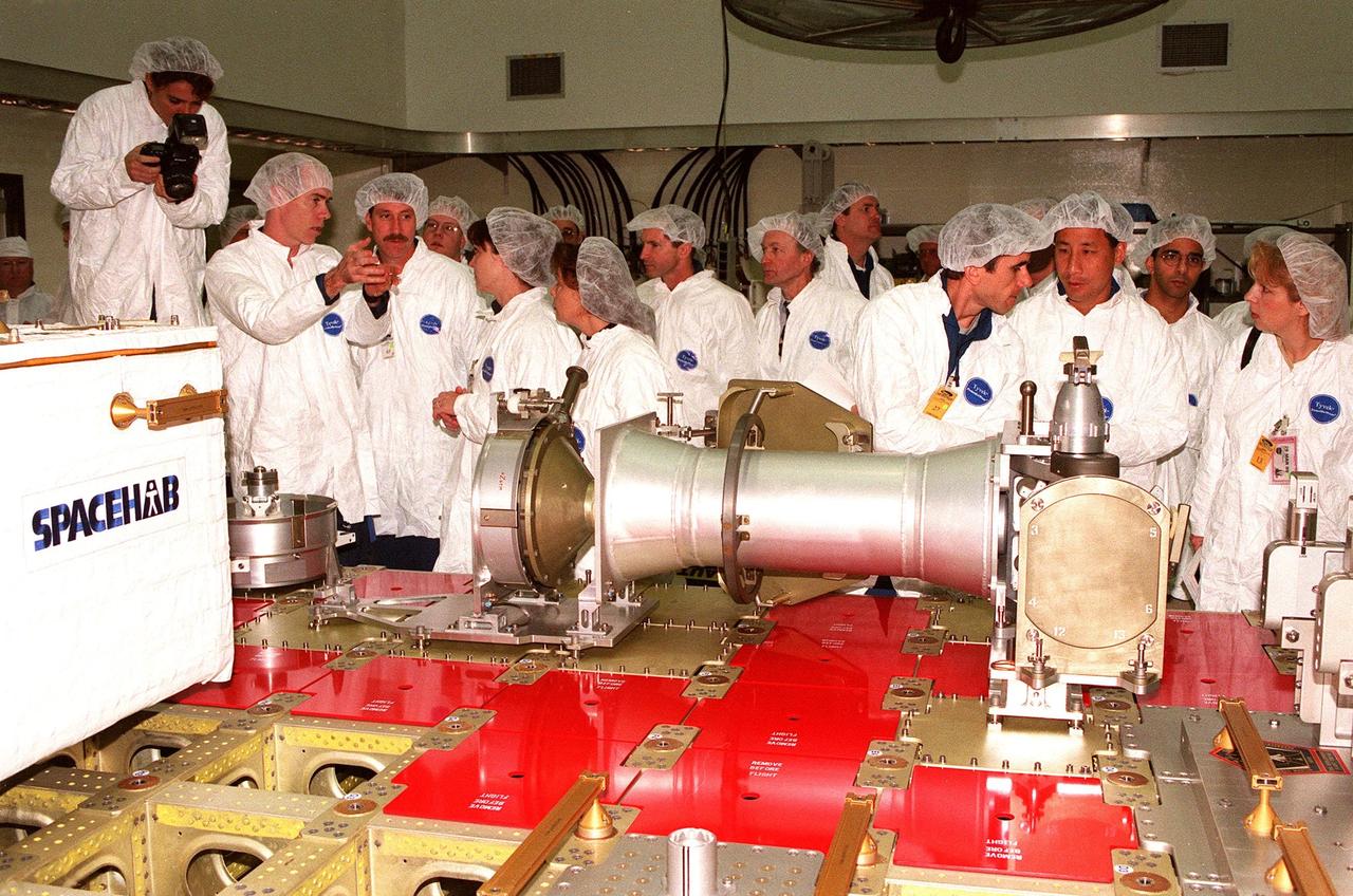 At Astrotech in Titusville, Fla., members of two Shuttle crews look at components of a Russian cargo crane, the Strela, to be mounted to the exterior of the Russian station segment on the International Space Station (ISS). From left are STS-96 Mission Specialist Julie Payette and Daniel T. Barry, Commander Kent V. Rominger and Mission Specialist Tamara E. Jernigan; three technicians from DaimlerChrysler Aerospace; (in the background, facing right) STS-101 Commander James Donald Halsell Jr.; STS-101 Mission Specialists Yuri Ivanovich Malenchenko, with the Russian Space Agency, and Edward Tsang Lu; and two more technicians from DaimlerChrysler. Both missions include the SPACEHAB Double Module, carrying internal and resupply cargo for Station outfitting. For the first time, STS-96 will include an Integrated Cargo Carrier (ICC) that will carry the Strela; the SPACEHAB Oceaneering Space System Box (SHOSS), which is a logistics items carrier; and a U.S.-built crane (ORU Transfer Device, or OTD) that will be stowed on the station for use during future ISS assembly missions. The ICC can carry up to 6,000 lb of unpressurized payload. It was built for SPACEHAB by DaimlerChrysler and RSC Energia of Korolev, Russia. STS-96 is targeted for launch on May 24 from Launch Pad 39B. STS-101 is scheduled to launch in early December 1999