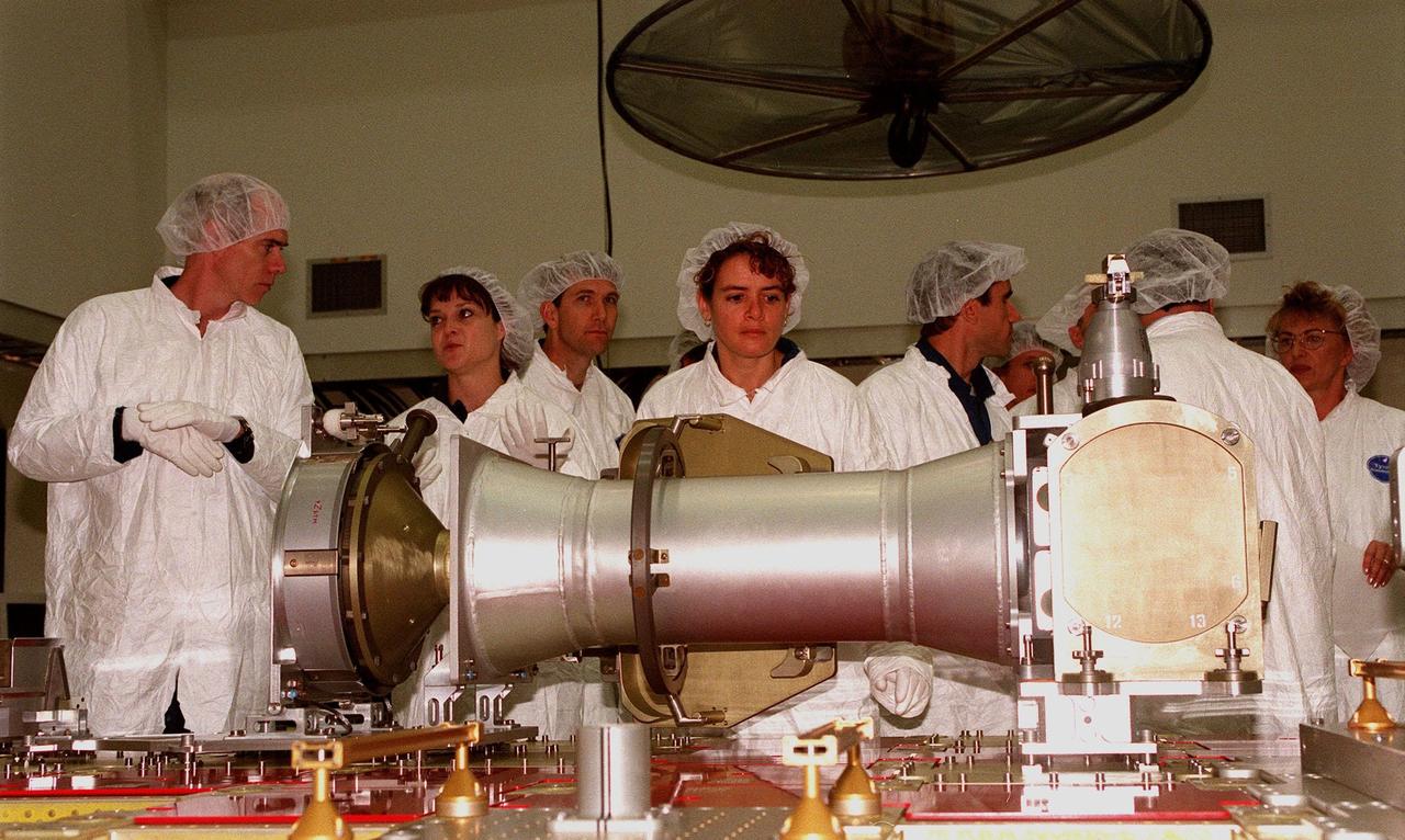 At Astrotech in Titusville, Fla., members of two Shuttle crews take a close look at components of a Russian cargo crane, the Strela, to be mounted to the exterior of the Russian station segment on the International Space Station (ISS). From left are STS-96 Mission Specialists Daniel T. Barry and Tamara E. Jernigan, Pilot Rick Douglas Husband, and Mission Specialist Julie Payette; next to them is STS-101 Mission Specialist Yuri Ivanovich Malenchenko, with the Russian Space Agency. Both missions include the SPACEHAB Double Module, carrying internal and resupply cargo for Station outfitting. For the first time, STS-96 will include an Integrated Cargo Carrier (ICC) that will carry the Strela; the SPACEHAB Oceaneering Space System Box (SHOSS), which is a logistics items carrier; and a U.S.-built crane (ORU Transfer Device, or OTD) that will be stowed on the station for use during future ISS assembly missions. The ICC can carry up to 6,000 lb of unpressurized payload. It was built for SPACEHAB by DaimlerChrysler and RSC Energia of Korolev, Russia. STS-96 is targeted for launch on May 24 from Launch Pad 39B. STS-101 is scheduled to launch in early December 1999