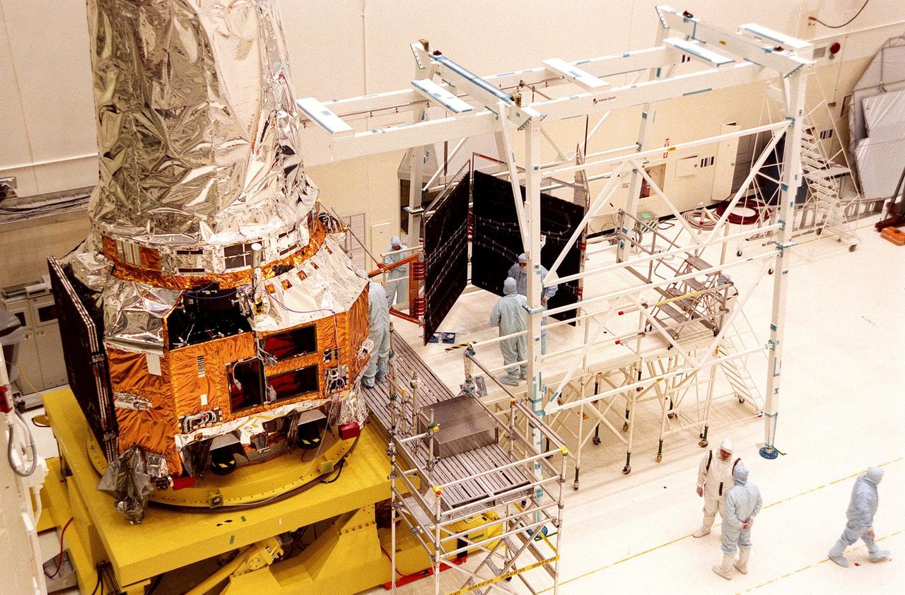 In the Vertical Processing Facility, TRW workers continue checking the deployment of the solar panel array (right) after attaching it to the Chandra X-ray Observatory (left). Formerly called the Advanced X-ray Astrophysics Facility, Chandra comprises three major elements: the spacecraft, the science instrument module (SIM), and the world's most powerful X-ray telescope. Chandra will allow scientists from around the world to see previously invisible black holes and high-temperature gas clouds, giving the observatory the potential to rewrite the books on the structure and evolution of our universe. Chandra is scheduled for launch July 9 aboard Space Shuttle Columbia, on mission STS-93