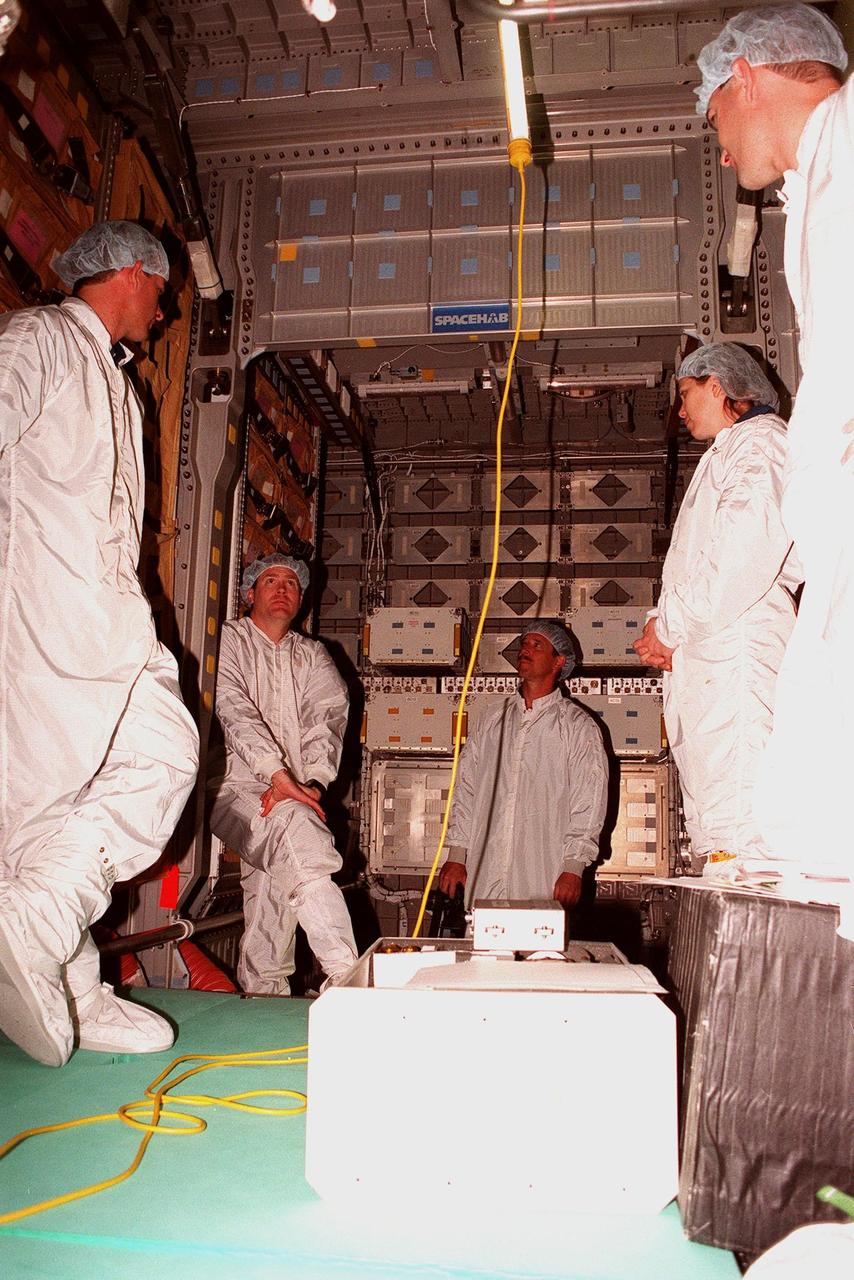 KENNEDY SPACE CENTER, FLA. -- Inside the SPACEHAB module, Chris Jaskoika (left), with Boeing SPACEHAB, works with members of the STS-101 crew during familiarization activities. Next to him are (left to right) Commander James Donald Halsell Jr., Pilot Scott "Doc" Horowitz (Ph.D.), and Mission Specialists Mary Ellen Weber (Ph.D.) and Jeffrey N. Williams. Mission STS-101 is the third flight in construction of the International Space Station. The 11-day mission is targeted for launch on December 2, 1999, at Launch Pad 39A