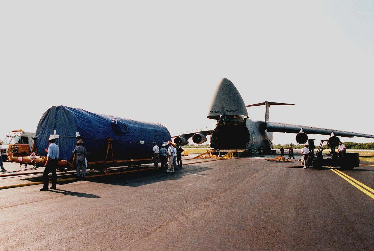 At Cape Canaveral Air Station, workers secure a Centaur upper stage on a transporter after offloading it from a U.S. Air Force C-5c (right). After being mated with the Atlas IIA lower stage, the rocket is scheduled to launch the NASA GOES-L satellite from Launch Pad 36A on May 15. Once in orbit, the satellite will become GOES-11, joining GOES-8, GOES-9 and GOES-10 in space. The fourth of a new advanced series of geostationary weather satellites for the National Oceanic and Atmospheric Administration (NOAA), GOES-L is a three-axis inertially stabilized spacecraft that will provide pictures and perform atmospheric sounding at the same time. Once launched, the satellite will undergo checkout and then provide backup capabilities for the existing, aging operational satellites