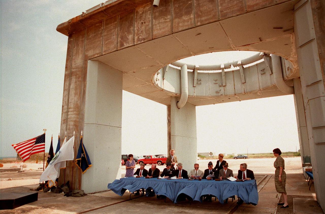 On the site of Launch Complex 34, key participants sign a Memorandum of Agreement, formalizing cooperative efforts of NASA, the U.S. Air Force, and federal agencies in ground-water cleanup initiatives. Seated at the table, from left to right, are Timothy Oppelt, director, National Risk Management Research Laboratory, U.S. Environmental Protection Agency; Tom Heenan, assistant manager of environmental management, Savannah River Site, U.S. Department of Energy; Col. James Heald, Vice Commander, Air Force Research Laboratory, U.S. Air Force; Gerald Boyd, acting deputy assistant secretary, Office of Science and Technology, U.S. Department of Energy; James Fiore, acting deputy assistant secretary, Office of Environmental Restoration, Department of Energy; Brig. Gen. Randall R. Starbuck, Commander 45th Space Wing, U.S. Air Force; Roy Bridges Jr., director of John F. Kennedy Space Center; Walter Kovalick Jr., Ph.D., director, Technology Innovation Office, U.S. Environmental Protection Agency. NASA, the U.S. Air Force and the agencies have formed a consortium and are participating in a comparative study of three innovative techniques to be used in cleaning a contaminated area of Launch Complex 34. The study will be used to help improve groundwater cleanup processes nationally