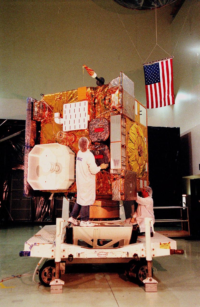 Workers at Astrotech, in Titusville, Fla., prepare the GOES-L satellite for a media showing. The GOES-L is due to be launched May 15 from Launch Pad 36A aboard an Atlas IIA rocket. Once in orbit, the satellite will become GOES-11, joining GOES-8, GOES-9 and GOES-10 in space. The fourth of a new advanced series of geostationary weather satellites for the National Oceanic and Atmospheric Administration (NOAA), GOES-L is a three-axis inertially stabilized spacecraft that will provide pictures and perform atmospheric sounding at the same time. Once launched, the satellite will undergo checkout and then provide backup capabilities for the existing, aging operational satellites