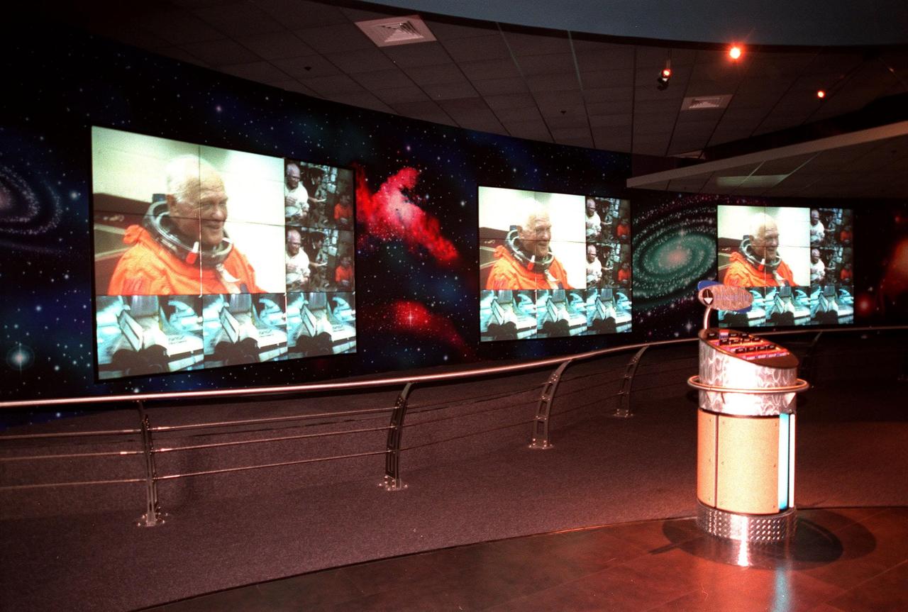 KENNEDY SPACE CENTER, FLA. -- Part of the $13 million expansion to KSC's Visitor Complex, the new information center welcomes visitors to the Gateway to the Universe. The five large video walls provide an orientation video, shown here with photos of John Glenn in his historic Shuttle mission in October 1998, with an introduction to the range of activities and exhibits, plus honor the center's namesake, President John F. Kennedy. Other new additions include a walk-through Robot Scouts exhibit, a wildlife exhibit, and the film Quest for Life in a new 300-seat theater, plus an International Space Station-themed ticket plaza, featuring a structure of overhanging solar panels and astronauts performing assembly tasks. The KSC Visitor Complex was inaugurated three decades ago and is now one of the top five tourist attractions in Florida. It is located on S.R. 407, east of I-95, within the Merritt Island National Wildlife Refuge