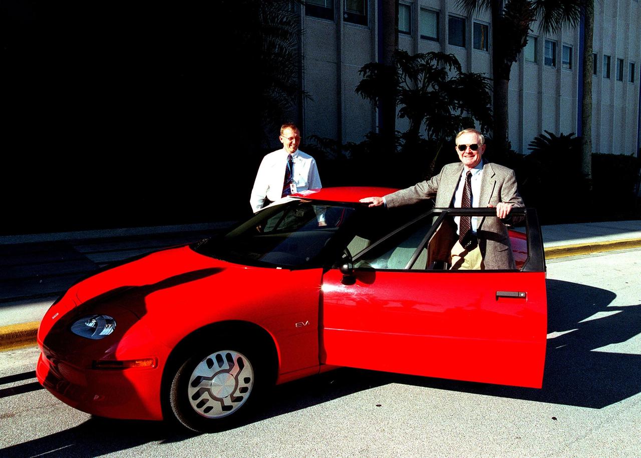 Center Director Roy Bridges (right) gets ready to drive an electric car, provided by Florida Power & Light, to the opening of Environmental and Energy Awareness Week at the Kennedy Space Center Visitor Complex. Exhibits and displays by KSC and 45th Space Wing organizations detail accomplishments in minimizing environmental impacts and conserving resources. They are on view April 19 22 at various sites at KSC, Cape Canaveral Air Station and Patrick Air Force Base