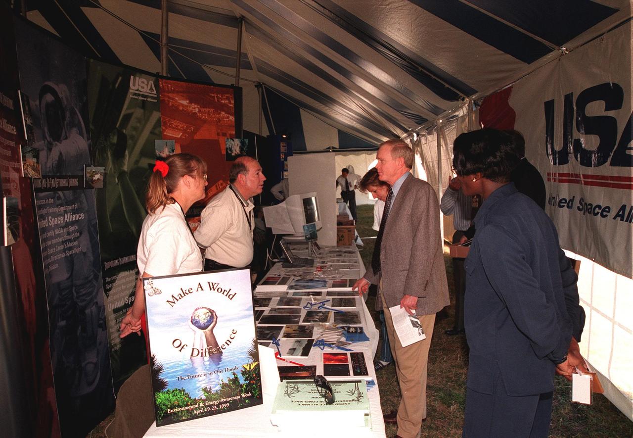 At the opening of Environmental and Energy Awareness Week at the Kennedy Space Center Visitor Complex, Center Director Roy Bridges talks to members of the Awareness team inside the United Space Alliance exhibit. The exhibits and displays by KSC and 45th Space Wing organizations detail accomplishments in minimizing environmental impacts and conserving resources. They are on view April 19 22 at various sites at KSC, Cape Canaveral Air Station and Patrick Air Force Base