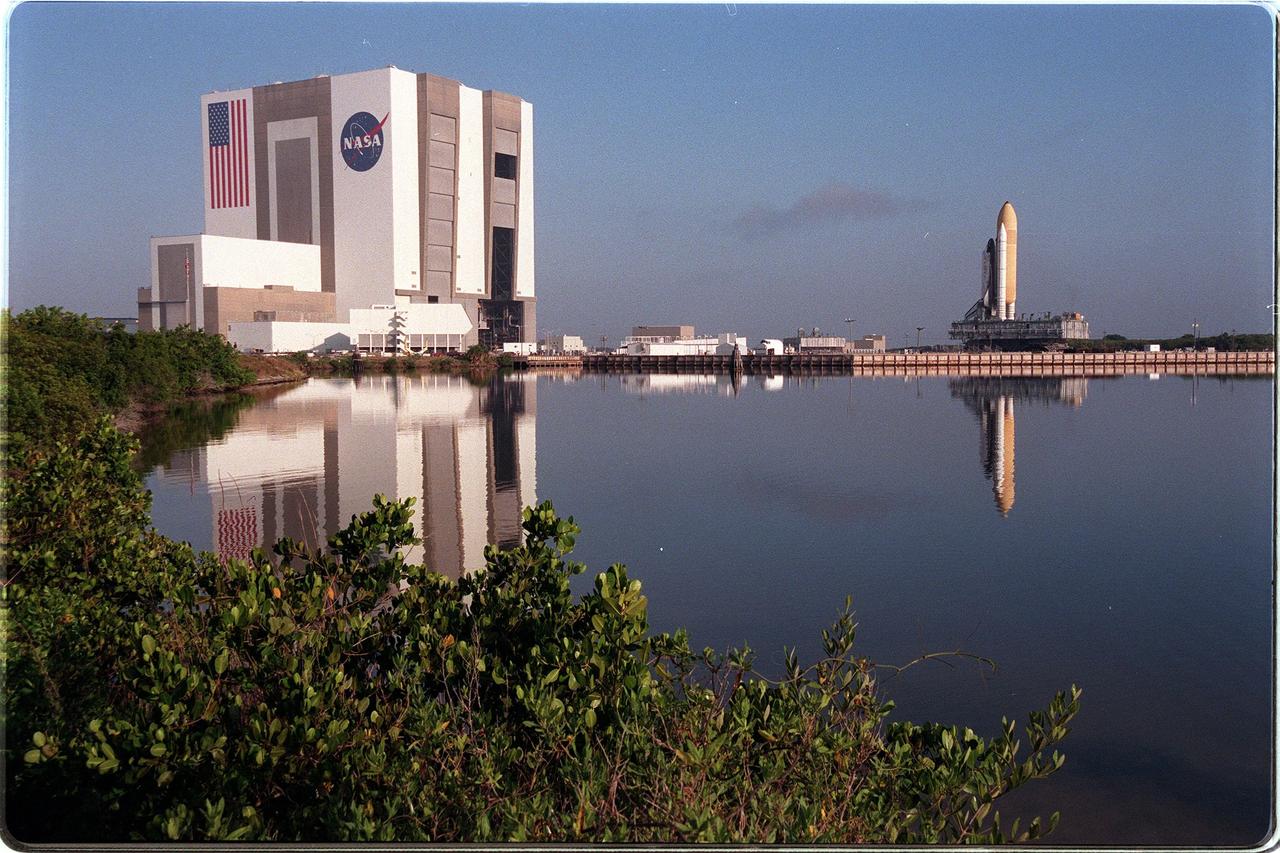 KENNEDY SPACE CENTER, Fla. -- Reflected in the turn basin at Launch Complex 39 Area, the Space Shuttle Discovery stands atop the crawler-transporter, which carries its cargo at 1 mph to Launch Pad 39B. The vehicle takes about five hours to cover the journey from the Vehicle Assembly Building to the launch pad. Liftoff of Discovery on mission STS-96 is targeted for May 20 at 9:32 a.m. EDT. STS-96 is a logistics and resupply mission for the International Space Station, carrying such payloads as a Russian crane, the Strela; a U.S.-built crane; the Spacehab Oceaneering Space System Box (SHOSS), a logistics items carrier; and STARSHINE, a student-led experiment