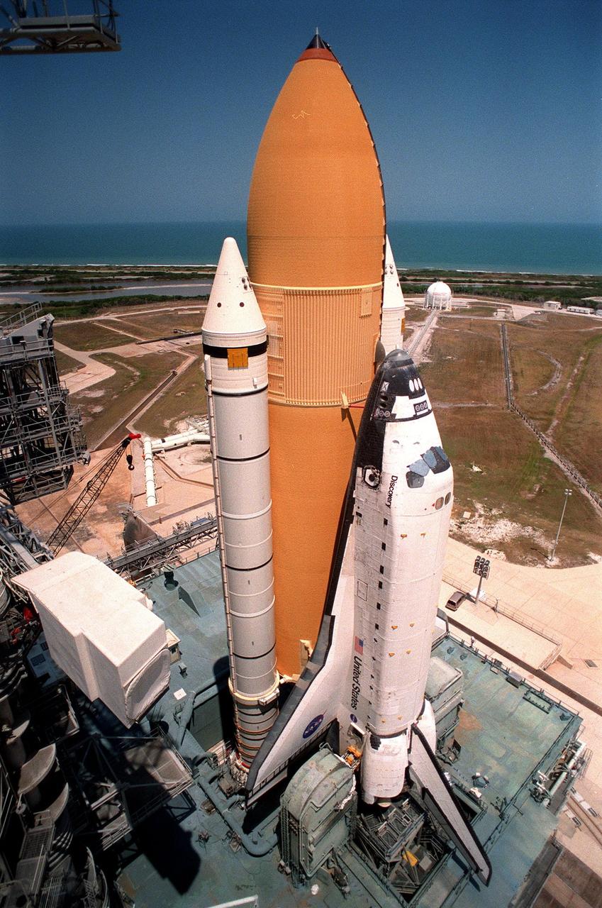 KENNEDY SPACE CENTER, FLA. -- Space Shuttle Discovery sits on launch Pad 39B, waiting for the rotating service structure to be moved into place for final launch preparations. At the top left of the photo is the end of the hammerhead crane, on the fixed service structure, that provides hoisting services required in pad operations. Liftoff of Discovery on mission STS-96 is targeted for May 20 at 9:32 a.m. EDT. STS-96 is a logistics and resupply mission for the International Space Station, carrying such payloads as a Russian crane, the Strela; a U.S.-built crane; the Spacehab Oceaneering Space System Box (SHOSS), a logistics items carrier; and STARSHINE, a student-led experiment