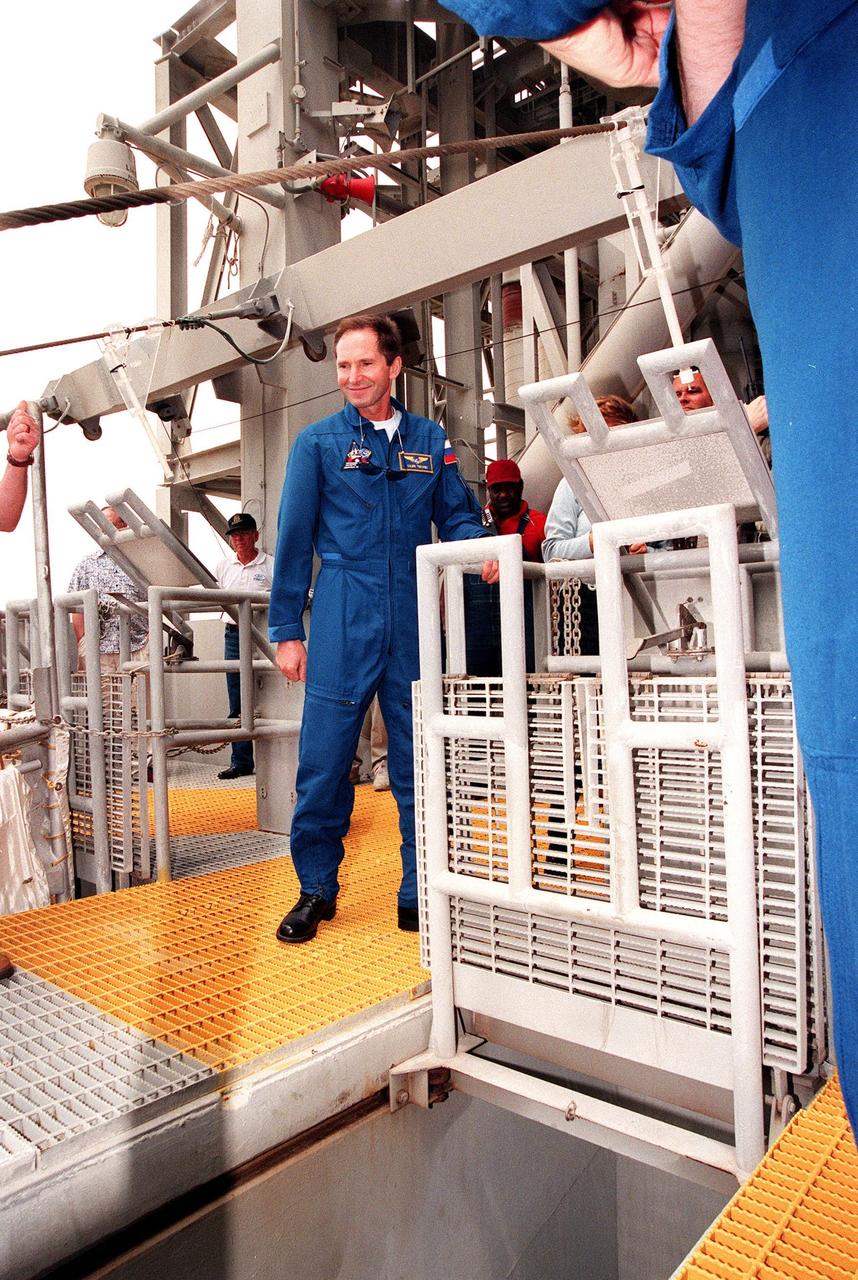 At the 195-foot level of Launch Pad 39B, STS-96 Mission Specialist Valery Ivanovich Tokarev releases a slidewire basket, part of emergency egress training. The STS-96 crew are taking part in Terminal Countdown Demonstration Test activities which also provide simulated countdown exercises and opportunities to inspect the mission payloads in the orbiter's payload bay. The other crew members are Commander Kent V. Rominger, Pilot Rick Douglas Husband and Mission Specialists Ellen Ochoa (Ph.D.), Tamara E. Jernigan (Ph.D.), Daniel Barry (M.D., Ph.D.) and Julie Payette, with the Canadian Space. STS-96, which is scheduled for liftoff on May 20 at 9:32 a.m., is a logistics and resupply mission for the International Space Station, carrying such payloads as a Russian crane, the Strela; a U.S.-built crane; the Spacehab Oceaneering Space System Box (SHOSS), a logistics items carrier; and STARSHINE, a student-led experiment