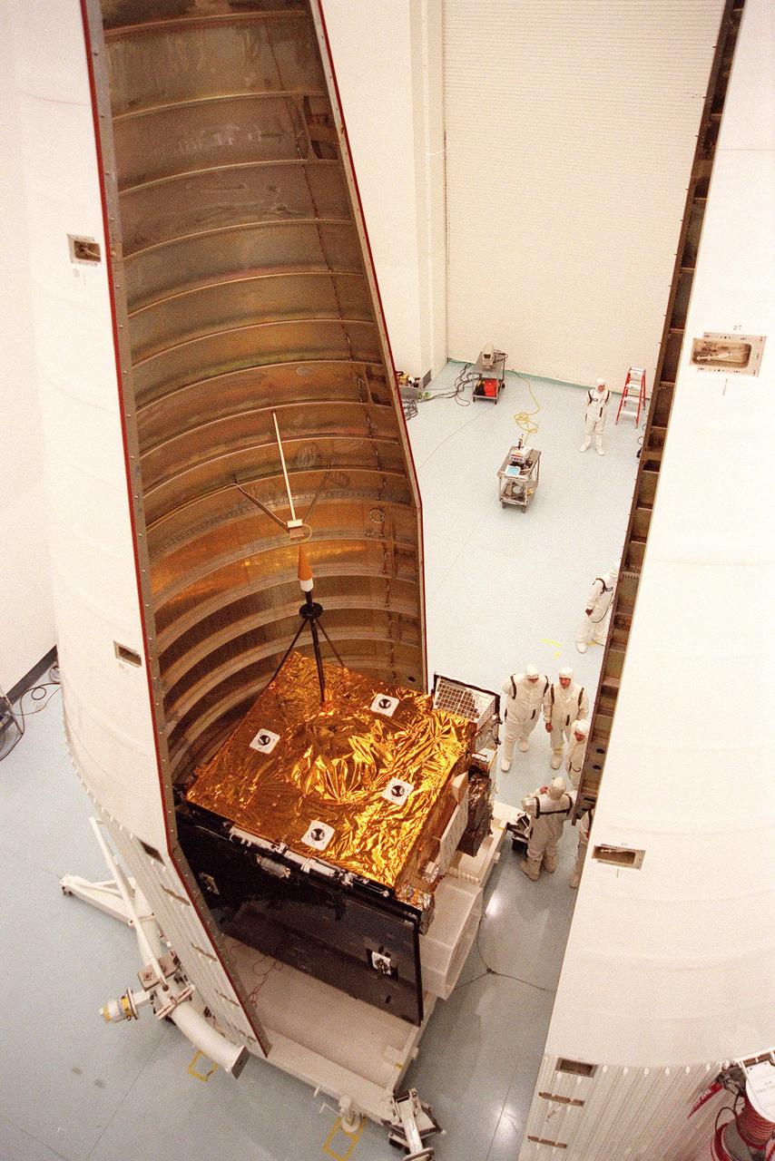At Astrotech, Titusville, Fla., the GOES-L weather satellite undergoes encapsulation in the first half of the fairing before its transfer to Launch Pad 36A, Cape Canaveral Air Station. At right is the second half of the fairing. The mounted equipment on top of the satellite is a telemetry and command antenna. The fourth of a new advanced series of geostationary weather satellites for the National Oceanic and Atmospheric Administration (NOAA), GOES-L is a three-axis inertially stabilized spacecraft that will provide pictures and perform atmospheric sounding at the same time. After it is launched, the satellite will undergo checkout and then provide backup capabilities for the existing, aging operational satellites. Once in orbit, the satellite will become GOES-11, joining GOES-8, GOES-9 and GOES-10 in space. The GOES is scheduled for launch aboard a Lockheed Martin Atlas II rocket later in May