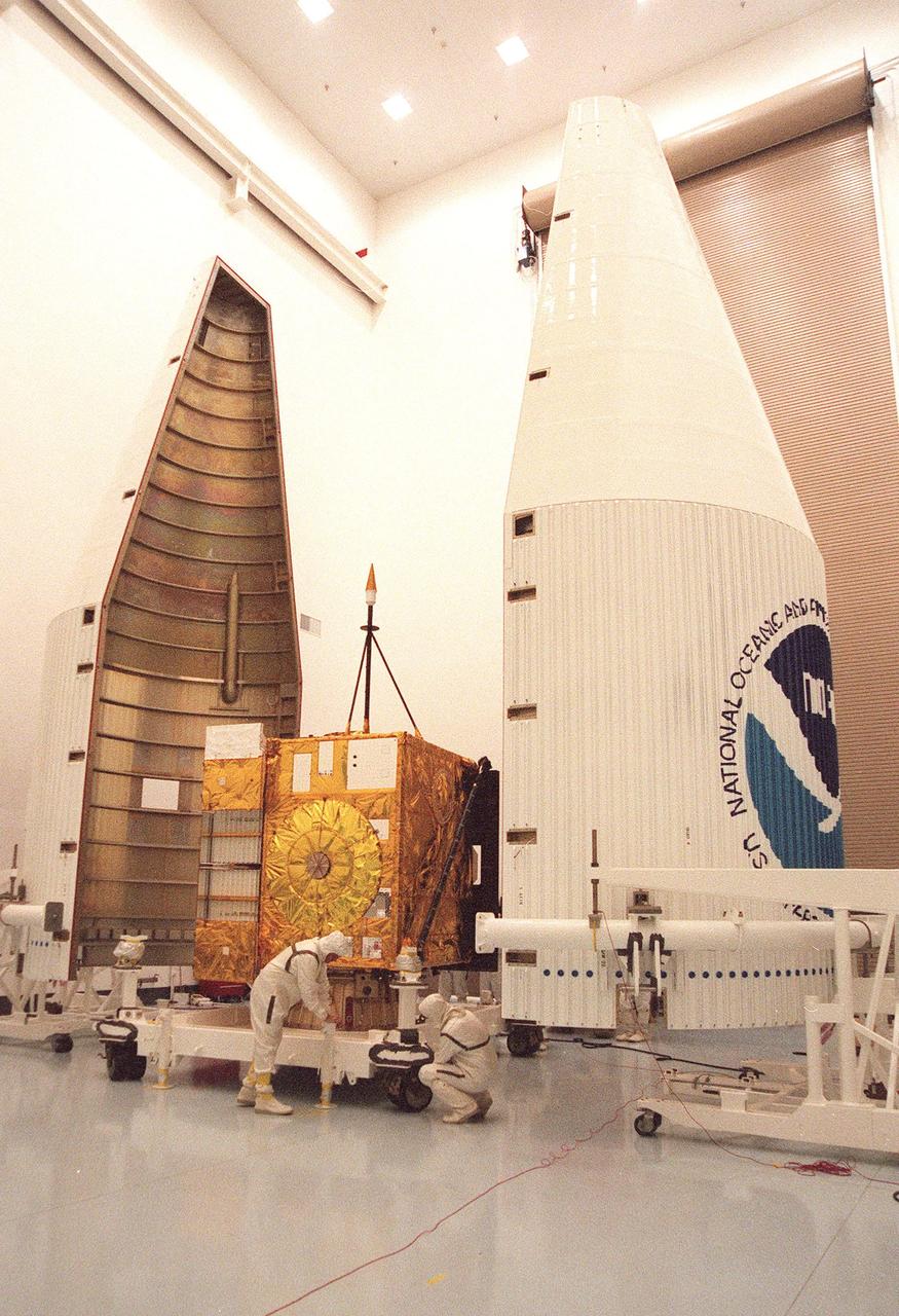 Workers at Astrotech, Titusville, Fla., prepare the GOES-L weather satellite for encapsulation in the fairing (left and right) before its transfer to Launch Pad 36A, Cape Canaveral Air Station. The mounted equipment on top of the satellite is a telemetry and command antenna. The fourth of a new advanced series of geostationary weather satellites for the National Oceanic and Atmospheric Administration (NOAA), GOES-L is a three-axis inertially stabilized spacecraft that will provide pictures and perform atmospheric sounding at the same time. After it is launched, the satellite will undergo checkout and then provide backup capabilities for the existing, aging operational satellites. Once in orbit, the satellite will become GOES-11, joining GOES-8, GOES-9 and GOES-10 in space. The GOES is scheduled for launch aboard a Lockheed Martin Atlas II rocket later in May