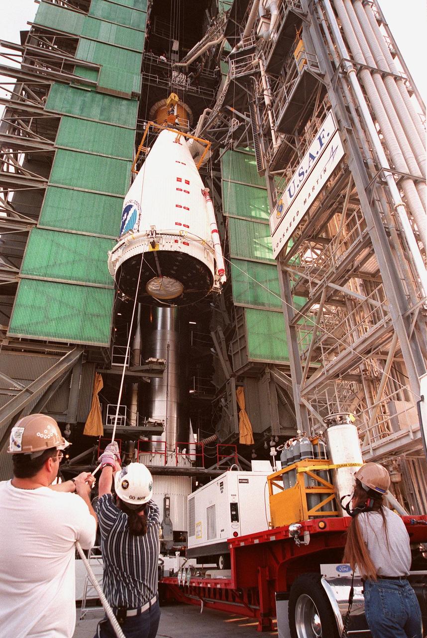 Workers at Launch Pad 36A, Cape Canaveral Air Station, help guide an encapsulated GOES-L weather satellite up the gantry for mating to a Lockheed Martin Atlas II rocket. The fourth of a new advanced series of geostationary weather satellites for the National Oceanic and Atmospheric Administration (NOAA), GOES-L is a three-axis inertially stabilized spacecraft that will provide pictures and perform atmospheric sounding at the same time. After it is launched, the satellite will undergo checkout and then provide backup capabilities for the existing, aging operational satellites. Once in orbit, the satellite will become GOES-11, joining GOES-8, GOES-9 and GOES-10 in space. The GOES is scheduled for launch later this month