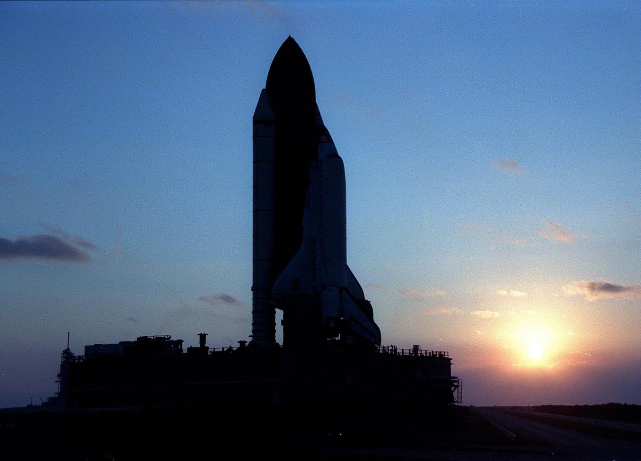 KENNEDY SPACE CENTER, FLA. -- As the sun begins to rise, a crawler transporter moves Space Shuttle Discovery from Pad 39B back to the Vehicle Assembly Building for repair of damage to the external tank foam insulation caused by hail. The necessary repair work could not be performed at the pad due to limited access to the damaged areas. The work is expected to take two to three days, allowing Discovery to roll back to the pad by midweek for launch of mission STS-96, the 94th launch in the Space Shuttle Program. This is only the 13th time since 1981 that a Shuttle has had to roll back from the pad. Liftoff will occur no earlier than May 27. STS-96 is a logistics and resupply mission for the International Space Station, carrying such payloads as a Russian crane, the Strela; a U.S.-built crane; the Spacehab Oceaneering Space System Box (SHOSS), a logistics items carrier; and STARSHINE, a student-shared experiment