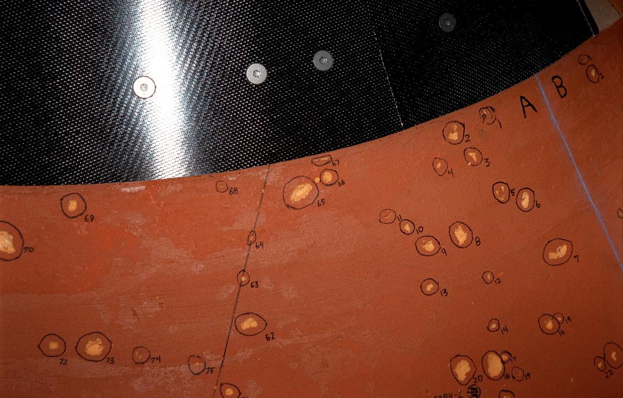 KENNEDY SPACE CENTER, FLA. -- Hail-inflicted divots in the foam insulation are identified by number on the top of Space Shuttle Discovery's external tank. About 150 divots were caused by hail during recent storms. The Shuttle was rolled back from Pad 39B to the Vehicle Assemby Building for repairs because access to all of the damaged areas was not possible at the pad. The work is expected to take two to three days, allowing Discovery to roll back to the pad as early as May 20 for launch of mission STS-96, the 94th launch in the Space Shuttle Program. Liftoff will occur no earlier than May 27. STS-96 is a logistics and resupply mission for the International Space Station, carrying such payloads as a Russian crane, the Strela; a U.S.-built crane; the Spacehab Oceaneering Space System Box (SHOSS), a logistics items carrier; and STARSHINE, a student-shared experiment