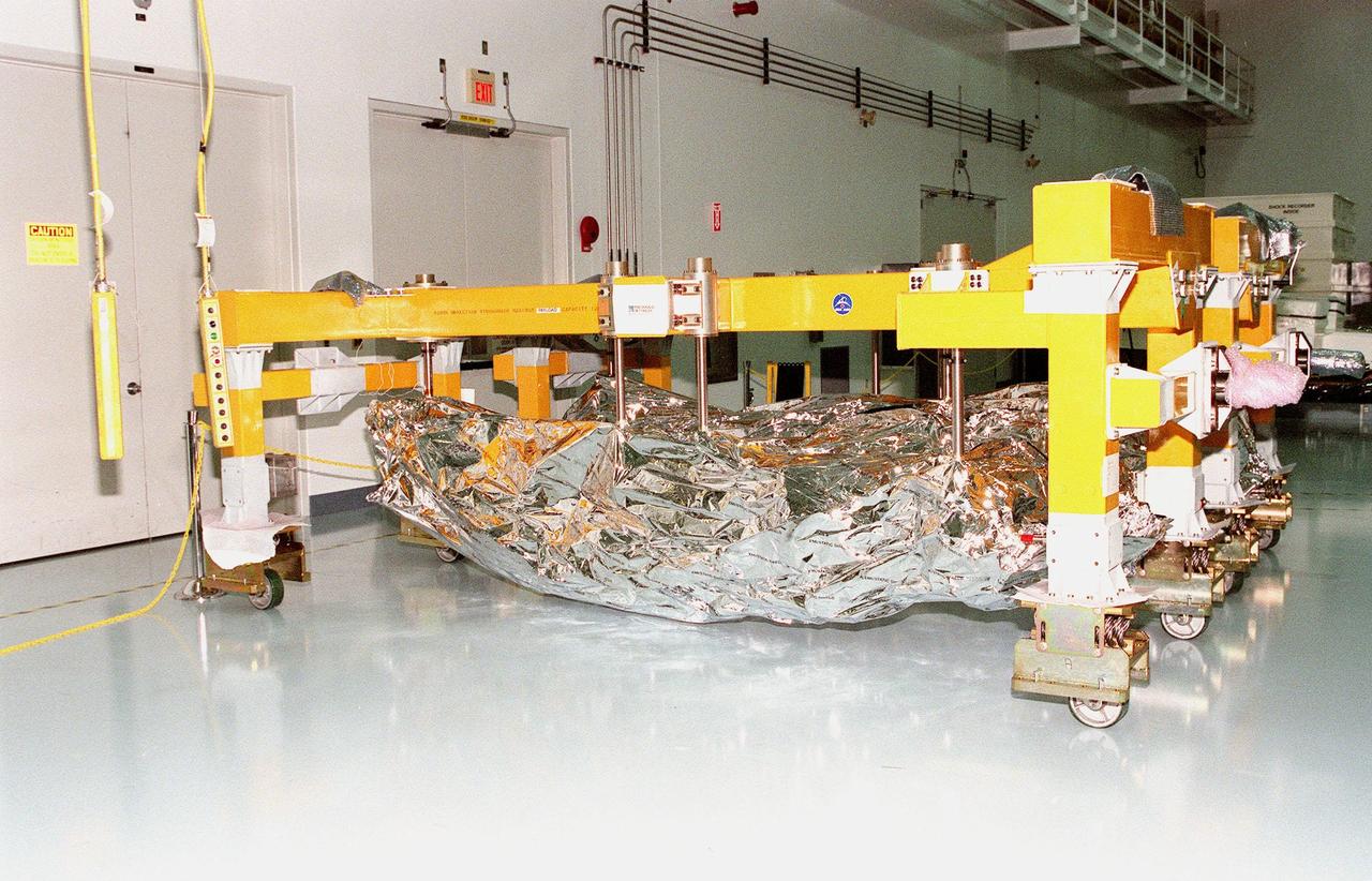 Segments of the Canadian Space Agency's (CSA) Space Station Remote Manipulator System (SSRMS) are lined up in the Space Station Processing Facility at KSC. They will undergo a campaign of prelaunch processing activities. CSA's first contribution to the International Space Station (ISS), the SSRMS is the primary means of transferring payloads between the orbiter payload bay and the ISS for assembly. The 56-foot-long robotic arm includes two 12-foot booms joined by a hinge. Seven joints on the arm allow highly flexible and precise movement. Latching End Effectors are mounted on each end of the arm for grappling. Video cameras mounted on the booms and end effectors will give astronauts maximum visibility for operations and maintenance tasks on the ISS. The SSRMS is scheduled to be launched aboard Space Shuttle Endeavour on STS-100, currently planned for July 2000