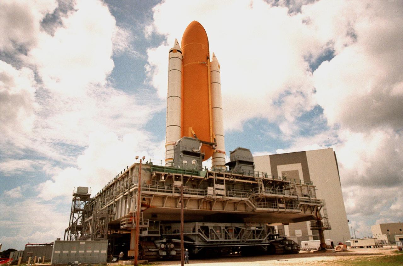 KENNEDY SPACE CENTER, FLA. -- The STS-93 stack of solid rocket boosters and external tank sits at the Mobile Launcher Platform park site waiting for lightning shield wires to be installed on the Vehicle Assembly Building (VAB) in the background. The stack is being temporarily stored outside the VAB while Space Shuttle Discovery undergoes repair to hail damage in High Bay 1. Discovery was rolled back from Pad 39B to the VAB for repairs because access to all of the damaged areas was not possible at the pad. The STS-93 stack will be moved under the wires at the VAB for protection until Discovery returns to the pad, later this week. The scheduled date for launch of mission STS-96 is no earlier than May 27. STS-93 is targeted for launch on July 22, carrying the Chandra X-ray Observatory