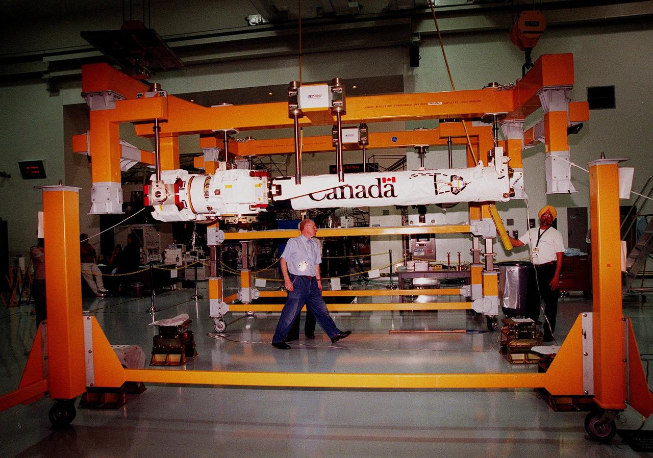 Workers in the Space Station Processing Facility raise a segment of the Canadian Space Agency's Space Station Remote Manipulator System (SSRMS) to move it to a workstand. CSA's first contribution to the International Space Station (ISS), the SSRMS is the primary means of transferring payloads between the orbiter payload bay and the ISS for assembly. The 56-foot-long robotic arm includes two 12-foot booms joined by a hinge. Seven joints on the arm allow highly flexible and precise movement. Latching End Effectors are mounted on each end of the arm for grappling. Video cameras mounted on the booms and end effectors will give astronauts maximum visibility for operations and maintenance tasks on the ISS. The SSRMS is at KSC to begin a campaign of prelaunch processing activities. It is scheduled to be launched aboard Space Shuttle Endeavour on mission STS-100, currently planned for July 2000