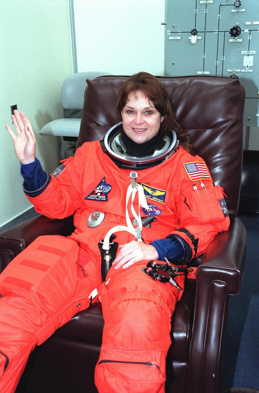 In the Operations and Checkout Building, STS-96 Mission Specialist Tamara E. Jernigan waves after donning her launch and entry suit during final launch preparations. STS-96 is a 10-day logistics and resupply mission for the International Space Station, carrying about 4,000 pounds of supplies, to be stored aboard the station for use by future crews, including laptop computers, cameras, tools, spare parts, and clothing. The mission also includes such payloads as a Russian crane, the Strela; a U.S.-built crane; the Spacehab Oceaneering Space System Box (SHOSS), a logistics items carrier; and STARSHINE, a student-involved experiment. It will include a space walk to attach the cranes to the outside of the ISS for use in future construction.. Space Shuttle Discovery is due to launch today at 6:49 a.m. EDT. Landing is expected at the SLF on June 6 about 1:58 a.m. EDT