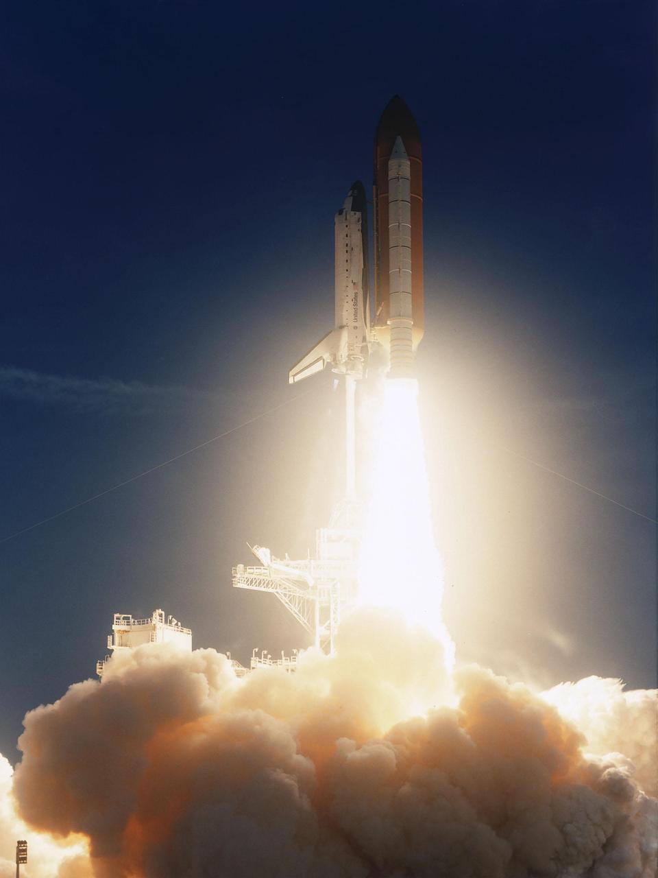 KENNEDY SPACE CENTER, FLA. -- In the early dawn, the brilliant flames from the launch of Space Shuttle Discovery light up the billows of steam below. Mission STS-96 lifted off at 6:49:42 a.m. EDT. The crew of seven begin a 10-day logistics and resupply mission for the International Space Station, carrying about 4,000 pounds of supplies, to be stored aboard the station for use by future crews, including laptop computers, cameras, tools, spare parts, and clothing. The mission also includes such payloads as a Russian crane, the Strela; a U.S.-built crane; the Spacehab Oceaneering Space System Box (SHOSS), a logistics items carrier; and STARSHINE, a student-involved experiment. It will include a space walk to attach the cranes to the outside of the ISS for use in future construction. Landing is expected at the SLF on June 6 about 1:58 a.m. EDT