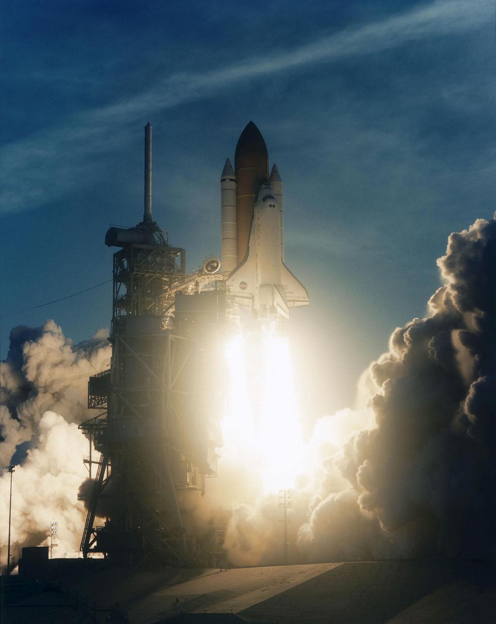 KENNEDY SPACE CENTER, FLA. -- Competing with the sunrise, the brilliant flames from the launch of Space Shuttle Discovery light up the morning sky. Mission STS-96 lifted off at 6:49:42 a.m. EDT. The crew of seven begin a 10-day logistics and resupply mission for the International Space Station, carrying about 4,000 pounds of supplies, to be stored aboard the station for use by future crews, including laptop computers, cameras, tools, spare parts, and clothing. The mission also includes such payloads as a Russian crane, the Strela; a U.S.-built crane; the Spacehab Oceaneering Space System Box (SHOSS), a logistics items carrier; and STARSHINE, a student-involved experiment. It will include a space walk to attach the cranes to the outside of the ISS for use in future construction. Landing is expected at the SLF on June 6 about 1:58 a.m. EDT