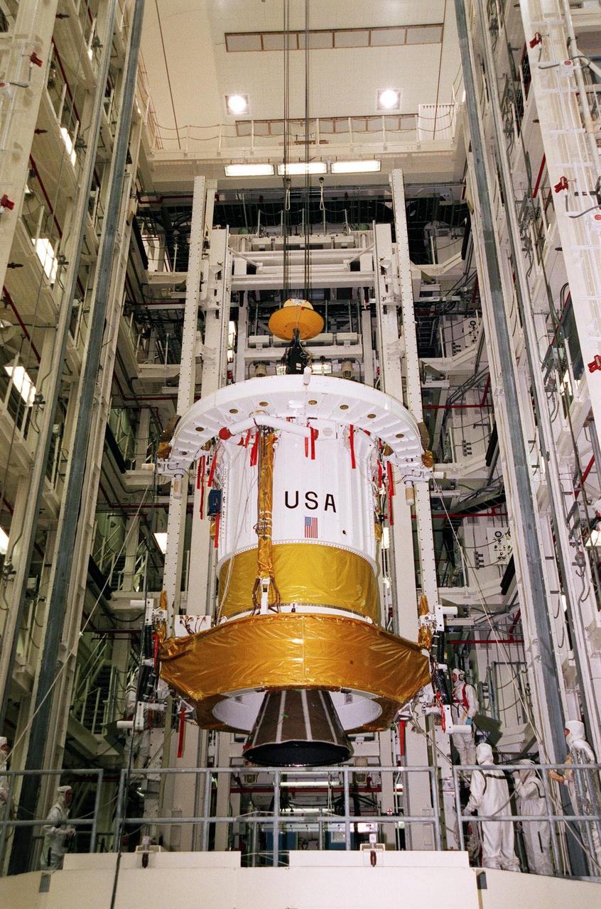 The Inertial Upper Stage (IUS) booster is lowered toward a workstand in Kennedy Space Center's Vertical Processing Facility. The IUS will be mated with the Chandra X-ray Observatory and then undergo testing to validate the IUS/Chandra connections and check the orbiter avionics interfaces. Following that, an end-to-end test (ETE) will be conducted to verify the communications path to Chandra, commanding it as if it were in space. With the world's most powerful X-ray telescope, Chandra will allow scientists from around the world to see previously invisible black holes and high-temperature gas clouds, giving the observatory the potential to rewrite the books on the structure and evolution of our universe. Chandra is scheduled for launch July 22 aboard Space Shuttle Columbia, on mission STS-93
