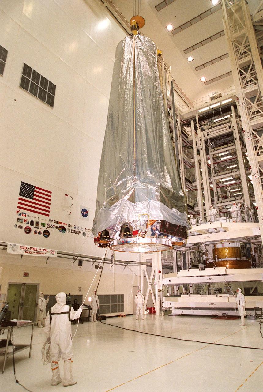 In the Vertical Processing Facility, the Chandra X-ray Observatory is moved toward the Inertial Upper Stage (IUS) in a workstand at right. There it will be mated with the IUS and then undergo testing to validate the IUS/Chandra connections and check the orbiter avionics interfaces. Following that, an end-to-end test (ETE) will be conducted to verify the communications path to Chandra, commanding it as if it were in space. With the world's most powerful X-ray telescope, Chandra will allow scientists from around the world to see previously invisible black holes and high-temperature gas clouds, giving the observatory the potential to rewrite the books on the structure and evolution of our universe. Chandra is scheduled for launch July 22 aboard Space Shuttle Columbia, on mission STS-93