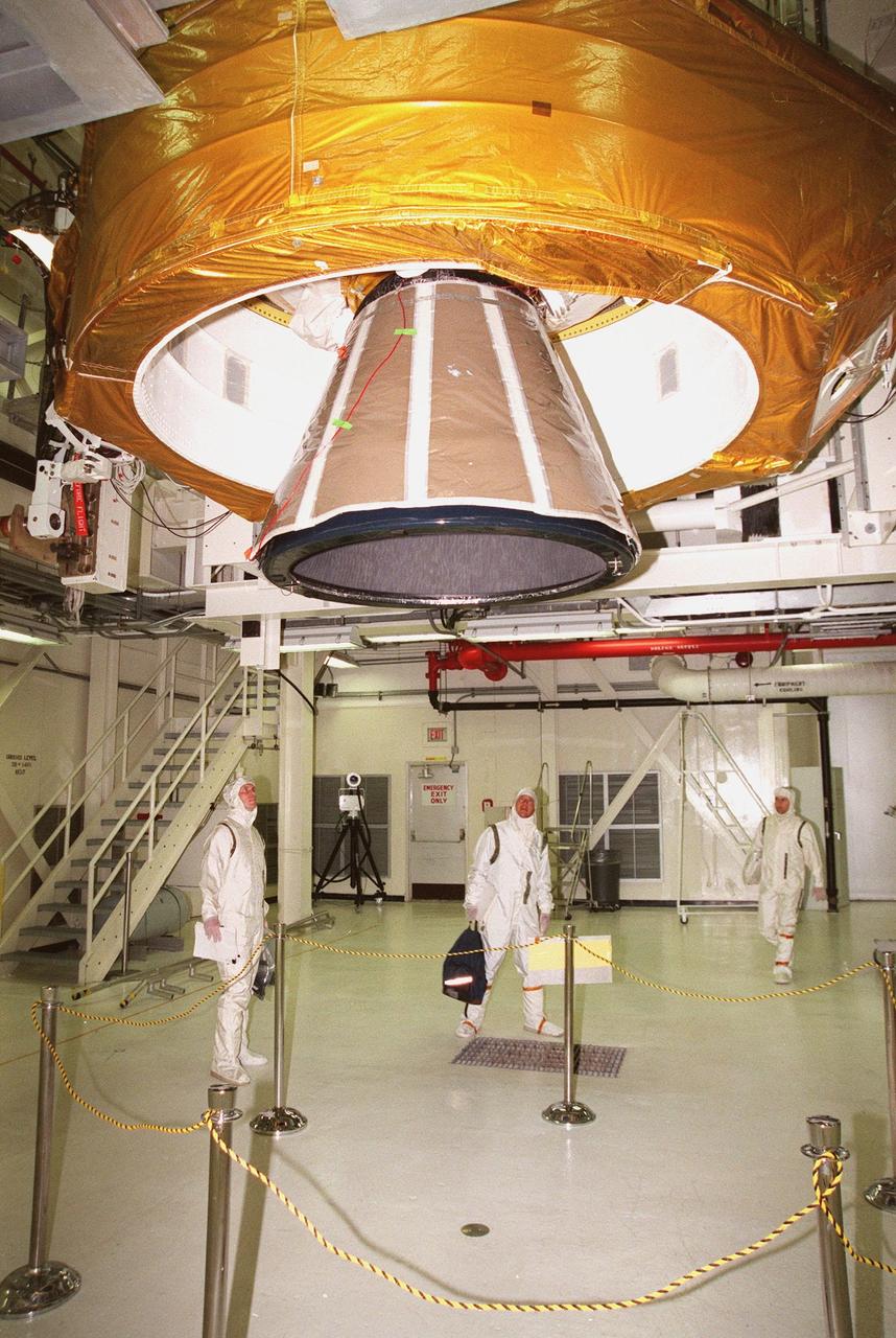 Workers in the Vertical Processing Facility observe the lower end of the Inertial Upper Stage (IUS) that will be mated with the Chandra X-ray Observatory (out of sight above it). After the two components are mated, they will undergo testing to validate the IUS/Chandra connections and to check the orbiter avionics interfaces. Following that, an end-to-end test (ETE) will be conducted to verify the communications path to Chandra, commanding it as if it were in space. With the world's most powerful X-ray telescope, Chandra will allow scientists from around the world to see previously invisible black holes and high-temperature gas clouds, giving the observatory the potential to rewrite the books on the structure and evolution of our universe. Chandra is scheduled for launch July 22 aboard Space Shuttle Columbia, on mission STS-93