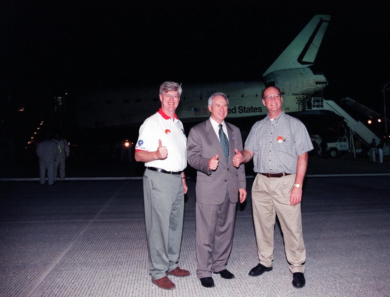 (Left to right) Canadian Minister of Industry John Manley, NASA administrator Daniel Goldin, and President of the Canadian Space Agency Mac Evans give a thumbs up to the end of a successful mission after Space Shuttle orbiter Discovery (behind them) touched down on KSC's Shuttle Landing Facility Runway 15. Main gear touchdown occurred at 2:02:43 a.m. EDT to complete the 9-day, 19-hour, 13-minute and 1-second long STS-96 mission. Onboard the Shuttle was Mission Specialist Julie Payette, who represents the Canadian Space Agency. At the controls for the landing were Commander Kent V. Rominger and Pilot Rick D. Husband. Others onboard were Mission Specialists Ellen Ochoa (Ph.D.), Tamara E. Jernigan (Ph.D.), Daniel T. Barry (M.D., Ph.D.), and Valery Ivanovich Tokarev, represents the Russian Space Agency. The crew returned from the second flight to the International Space Station on a logistics and resupply mission