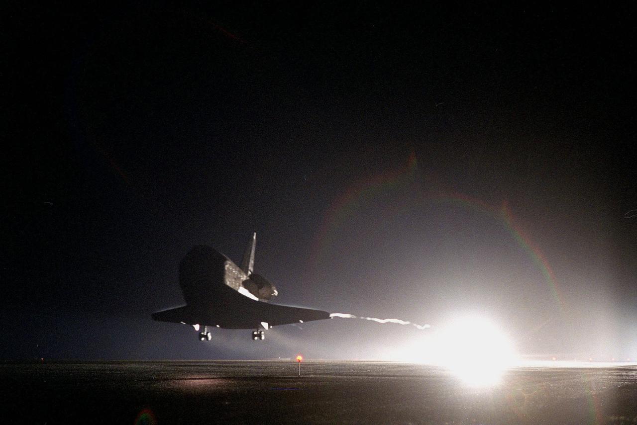 KENNEDY SPACE CENTER, Fla. -- Bright lights at KSC's Shuttle Landing Facility runway 15 illuminate the landing of Space Shuttle Discovery, which completes the 9-day, 19-hour, 13-minute and 1-second long STS-96 mission. A contrail streams from the wing. Main gear touchdown was at 2:02:43 a.m. EDT June 6 , landing on orbit 154 of the mission. Nose gear touchdown was at 2:02:59 a.m., and the wheels stopped at 2:03:39 a.m. At the controls were Commander Kent V. Rominger and Pilot Rick D. Husband. Also onboard the orbiter were Mission Specialists Ellen Ochoa (Ph.D.), Tamara E. Jernigan (Ph.D.), Daniel T. Barry (M.D., Ph.D.), Julie Payette and Valery Ivanovich Tokarev. Payette represents the Canadian Space Agency and Tokarev the Russian Space Agency. The crew returned from the second flight to the International Space Station on a logistics and resupply mission. This was the 94th flight in the Space Shuttle program and the 26th for Discovery, also marking the 47th at KSC, the 24th in the last 25 missions, 11th at night, and the 18th consecutive landing in Florida