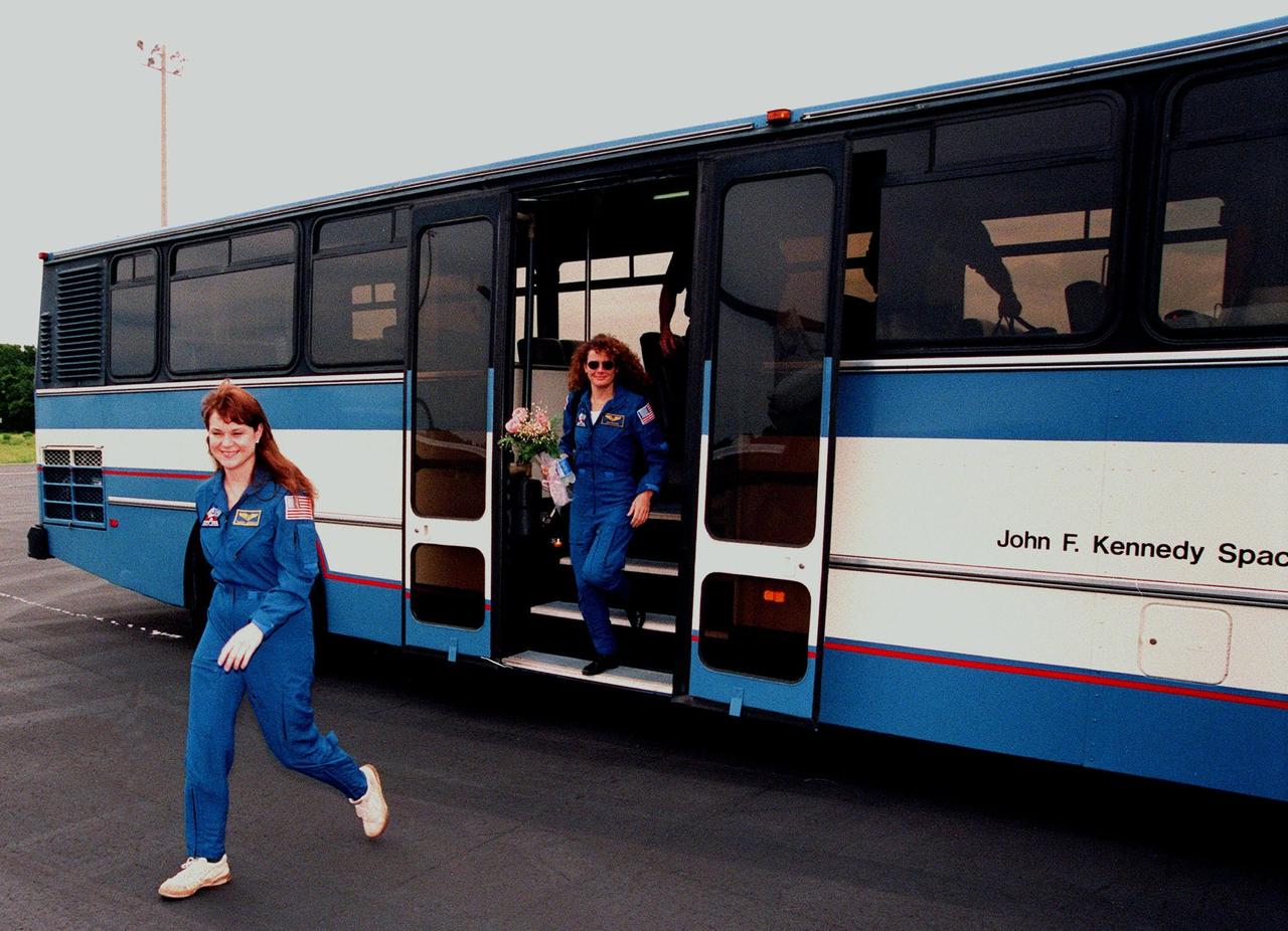 (Left to right) STS-96 Mission Specialists Tamara E. Jernigan (Ph.D.) and Julie Payette, with the Canadian Space Agency, leave the bus at the Cape Canaveral Air Station Skid Strip where they will board a plane to return to the Johnson Space Center in Houston, Texas. Other crew members also returning are Commander Kent V. Rominger, Pilot Rick D. Husband, and Mission Specialists Ellen Ochoa (Ph.D.), Daniel Barry (M.D., Ph.D.) and Valery Ivanovich Tokarev, with the Russian Space Agency. After a successful 10-day mission to the International Space Station aboard Space Shuttle Discovery, the crew landed June 6 at 2:02:43 a.m. EDT, in the 11th night landing at KSC