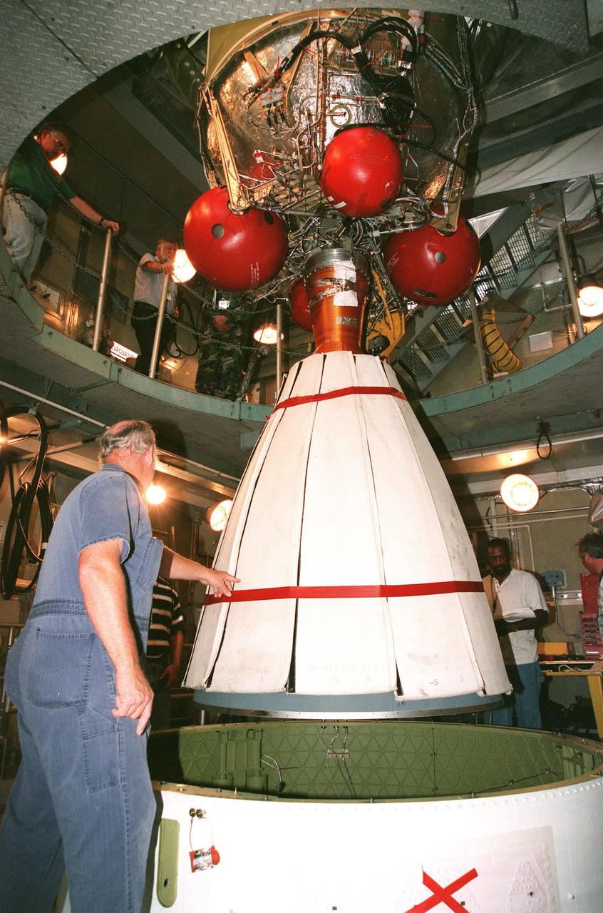 Under the watchful eyes of workers at Launch Pad 17A, Cape Canaveral Air Station (CCAS), the second stage of a Boeing Delta II rocket is lowered toward the first stage below. The first and second stages will be mated for the launch, targeted on June 23 at CCAS, , of NASA's Far Ultraviolet Spectroscopic Explorer (FUSE) satellite. FUSE was developed by The Johns Hopkins University under contract to Goddard Space Flight Center, Greenbelt, Md., to investigate the origin and evolution of the lightest elements in the universe hydrogen and deuterium. In addition, the FUSE satellite will examine the forces and process involved in the evolution of the galaxies, stars and planetary systems by investigating light in the far ultraviolet portion of the electromagnetic spectrum