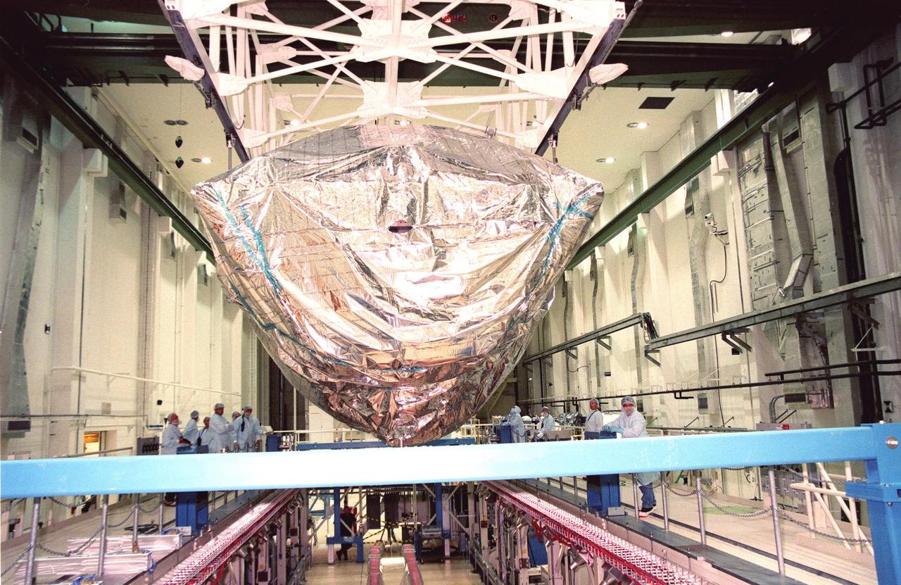 KENNEDY SPACE CENTER, FLA. -- Workers in the O&C Bldg. watch as the S0 truss is lowered onto a workstand. The S0 truss will undergo processing in the O&C during which the Canadian Mobile Transporter, power distribution system modules, a heat pipe radiator for cooling, computers, and a pair of rate gyroscopes will be installed. Four Global Positioning System antennas are already installed. A 44by 15-foot structure weighing 30,800 pounds when fully outfitted and ready for launch, the truss will be at the center of the ISS 10-truss, girderlike structure that will ultimately extend the length of a football field. Eventually the S0 truss will be attached to the U.S. Lab, "Destiny," which is scheduled to be added to the ISS in April 2000. Later, other trusses will be attached to the S0 on-orbit. The S0 truss is scheduled to be launched in the first quarter of 2001 on mission STS-108