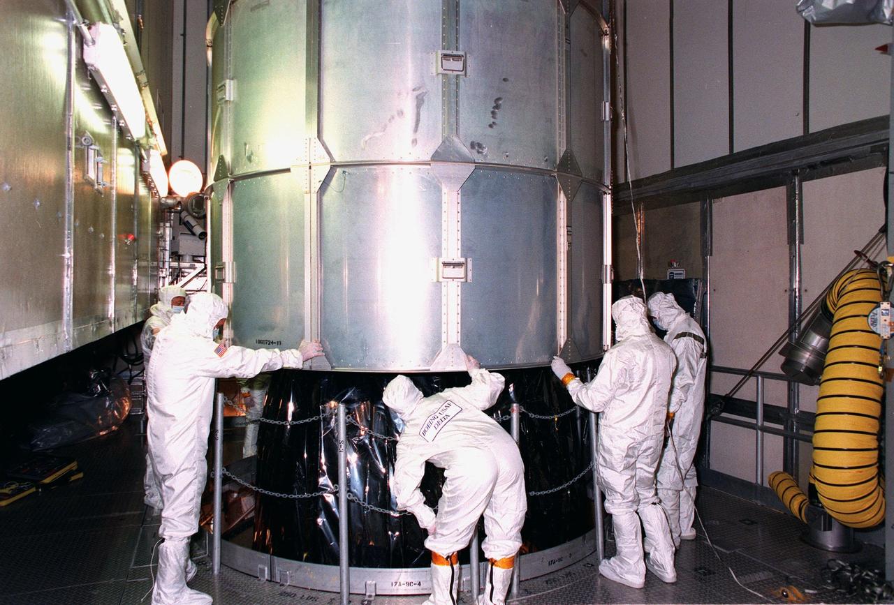 At Launch Pad 17A, Cape Canaveral Air Station (CCAS), workers begin to remove the canister around the top of the NASA's Far Ultraviolet Spectroscopic Explorer (FUSE) satellite. FUSE is designed to scour the cosmos for the fossil record of the origins of the universe hydrogen and deuterium. Scientists will use FUSE to study hydrogen and deuterium to unlock the secrets of how the primordial chemical elements of which all stars, planets and life evolved, were created and distributed since the birth of the universe. FUSE is scheduled to be launched from CCAS June 23 aboard a Boeing Delta II rocket