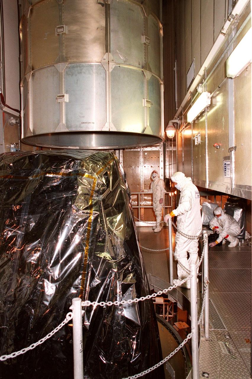 At Launch Pad 17A, Cape Canaveral Air Station (CCAS), workers oversee the removal of the canister from the top of NASA's Far Ultraviolet Spectroscopic Explorer (FUSE) satellite. FUSE is designed to scour the cosmos for the fossil record of the origins of the universe hydrogen and deuterium. Scientists will use FUSE to study hydrogen and deuterium to unlock the secrets of how the primordial chemical elements of which all stars, planets and life evolved, were created and distributed since the birth of the universe. FUSE is scheduled to be launched from CCAS June 23 aboard a Boeing Delta II rocket