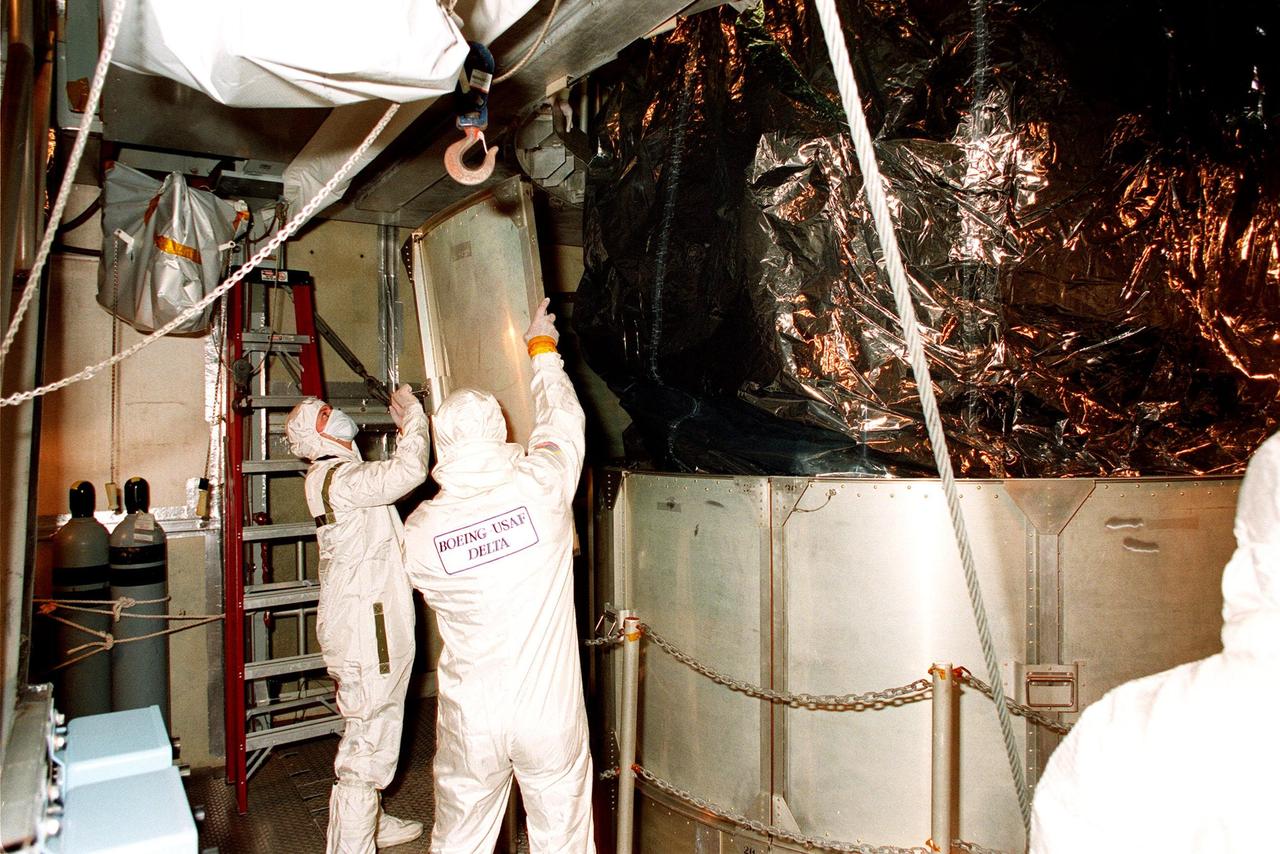 At Launch Pad 17A, Cape Canaveral Air Station (CCAS), workers begin removing the lower sections of the canister surrounding NASA's Far Ultraviolet Spectroscopic Explorer (FUSE) satellite. FUSE is designed to scour the cosmos for the fossil record of the origins of the universe hydrogen and deuterium. Scientists will use FUSE to study hydrogen and deuterium to unlock the secrets of how the primordial chemical elements of which all stars, planets and life evolved, were created and distributed since the birth of the universe. FUSE is scheduled to be launched from CCAS June 23 aboard a Boeing Delta II rocket