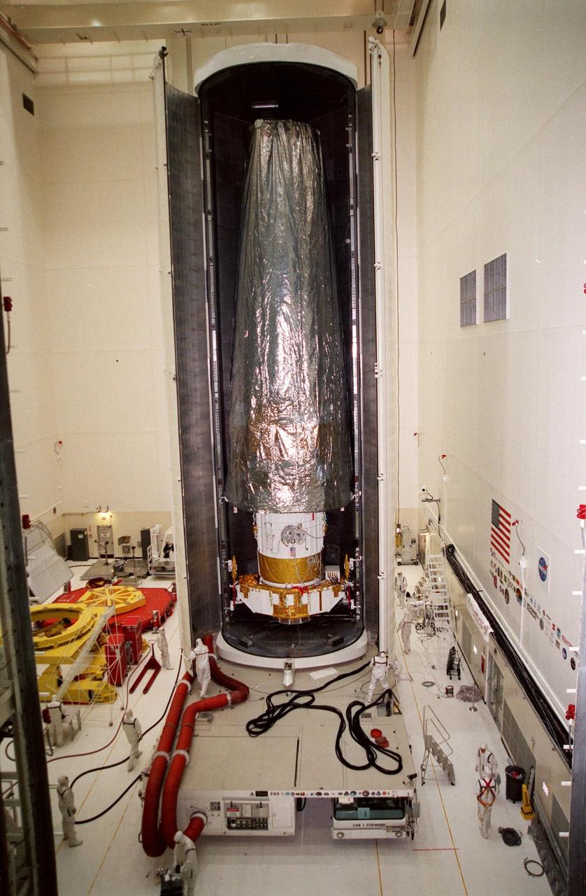 Inside the Vertical Processing Facility, the Chandra X-ray Observatory sits inside the payload canister, ready to be moved to Launch Pad 39B. Liftoff will take place no earlier than July 20 at 12:36 a.m. EDT aboard Space Shuttle Columbia, on mission STS-93. Chandra will allow scientists from around the world to obtain unprecedented X-ray images of exotic environments to help understand the structure and evolution of the universe. Chandra is expected to provide unique and crucial information on the nature of objects ranging from comets in our solar system to quasars at the edge of the observable universe, map the location of dark matter and help to identify it, and probe the faintest of active galaxies, allowing scientists to study not only how their energy output changes with time, but also how these objects produce their intense energy emissions in the first place. Since X-rays are absorbed by the Earth's atmosphere, space-based observatories are necessary to study these phenomena and allow scientists to analyze some of the greatest mysteries of the universe