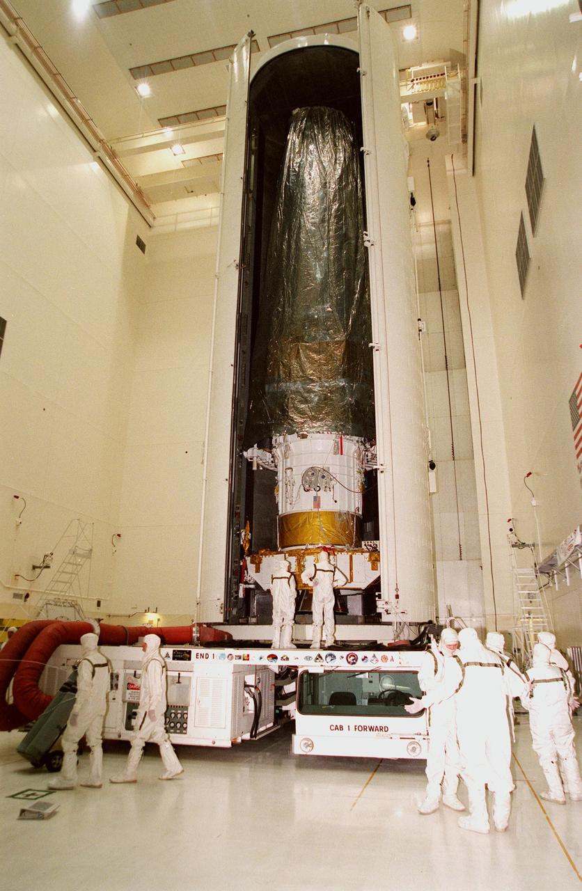 Inside the Vertical Processing Facility, doors on the payload canister begin to close on the Chandra X-ray Observatory inside before being moved to Launch Pad 39B. Liftoff will take place no earlier than July 20 at 12:36 a.m. EDT aboard Space Shuttle Columbia, on mission STS-93. Chandra will allow scientists from around the world to obtain unprecedented X-ray images of exotic environments to help understand the structure and evolution of the universe. Chandra is expected to provide unique and crucial information on the nature of objects ranging from comets in our solar system to quasars at the edge of the observable universe, map the location of dark matter and help to identify it, and probe the faintest of active galaxies, allowing scientists to study not only how their energy output changes with time, but also how these objects produce their intense energy emissions in the first place. Since X-rays are absorbed by the Earth's atmosphere, space-based observatories are necessary to study these phenomena and allow scientists to analyze some of the greatest mysteries of the universe